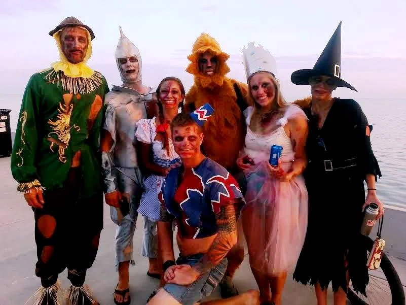 Friends in colourful costumes by the water