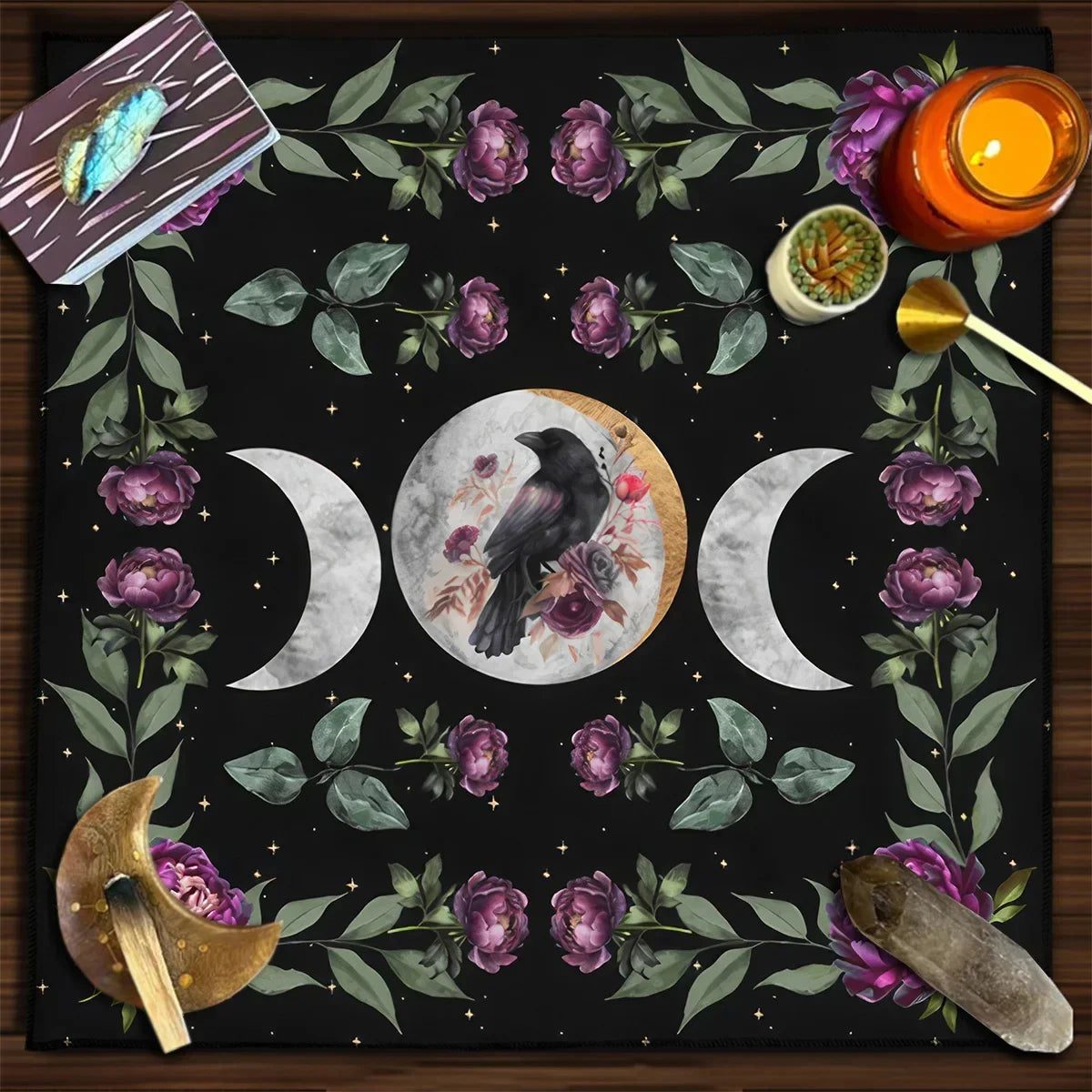 Triple moon and raven altar cloth with purple flowers, cards, and ritual objects