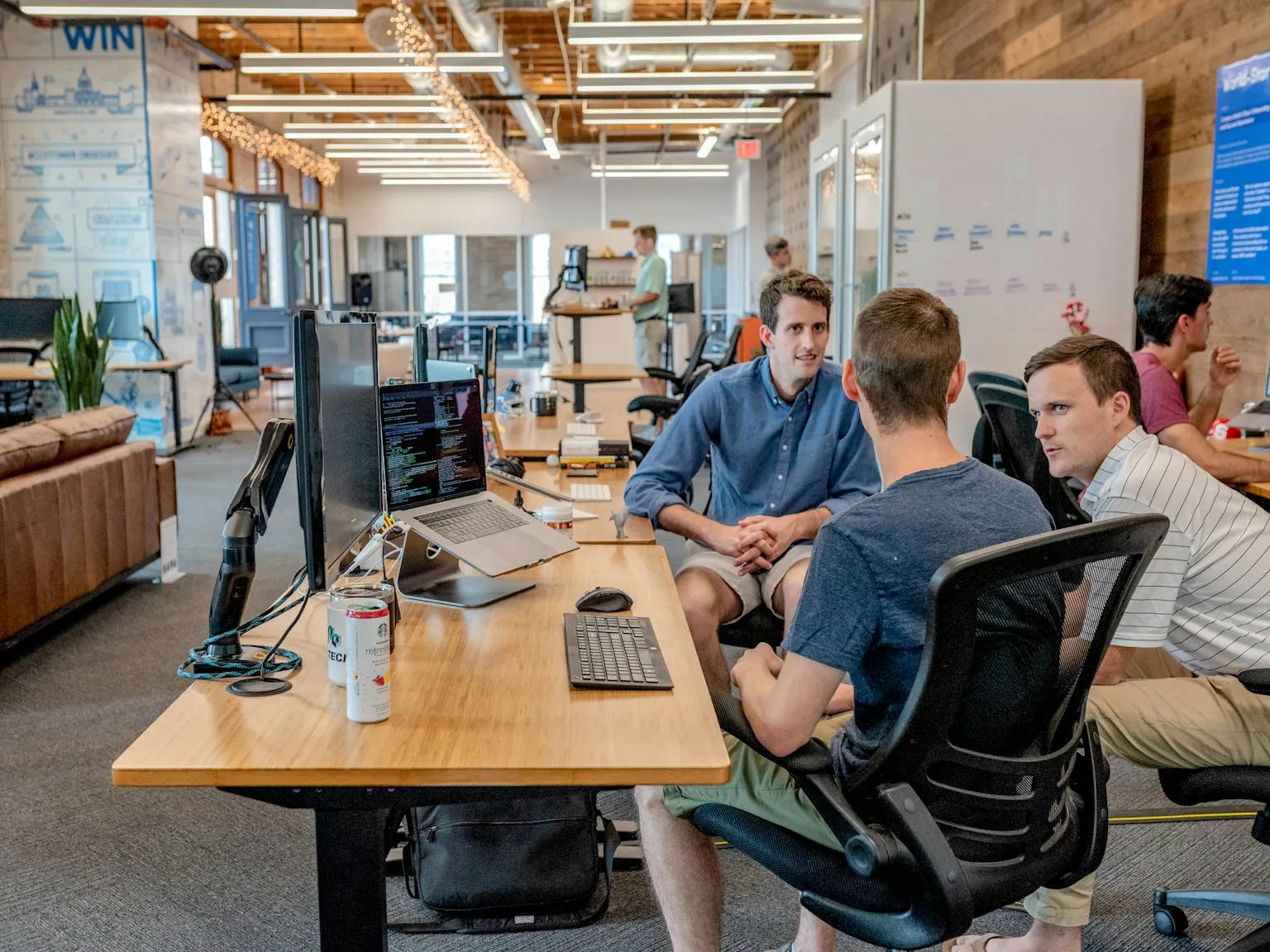 Coworkers gathered around a table in conversation.