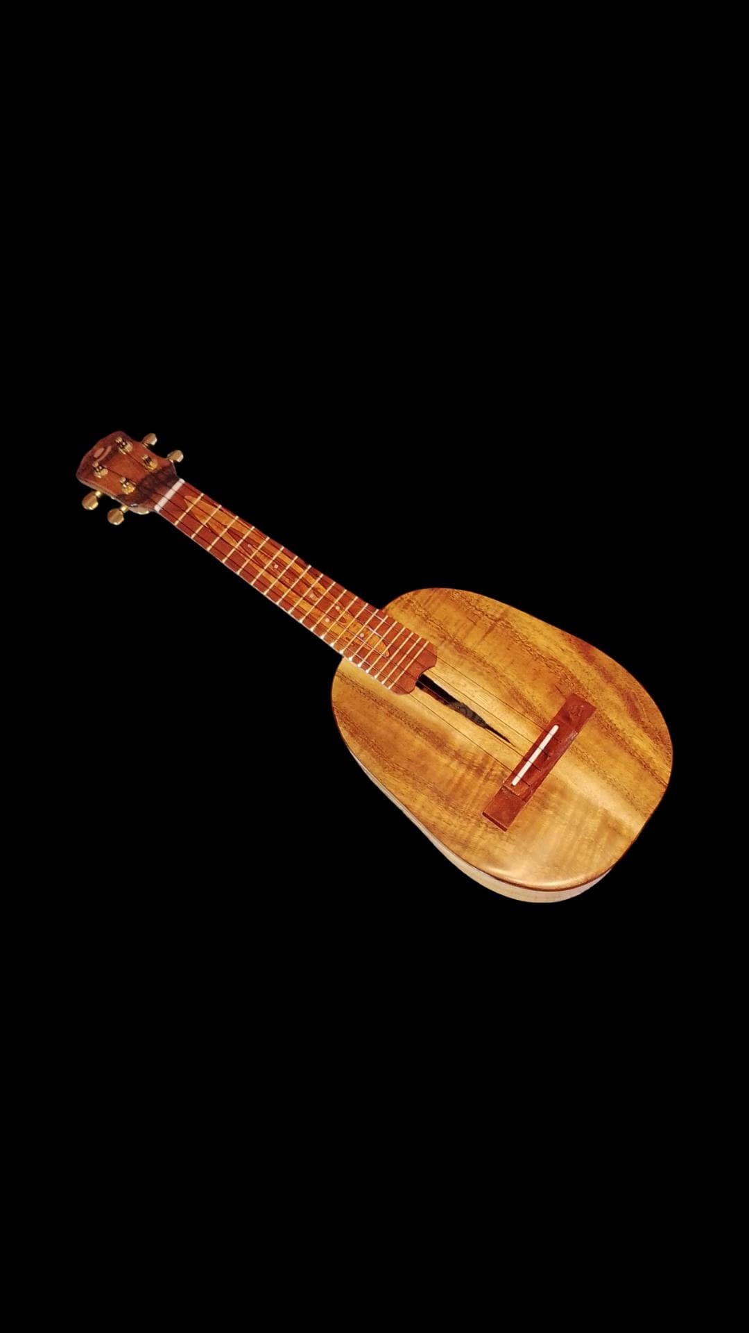Live-edge koa pineapple concert ukulele on a workbench