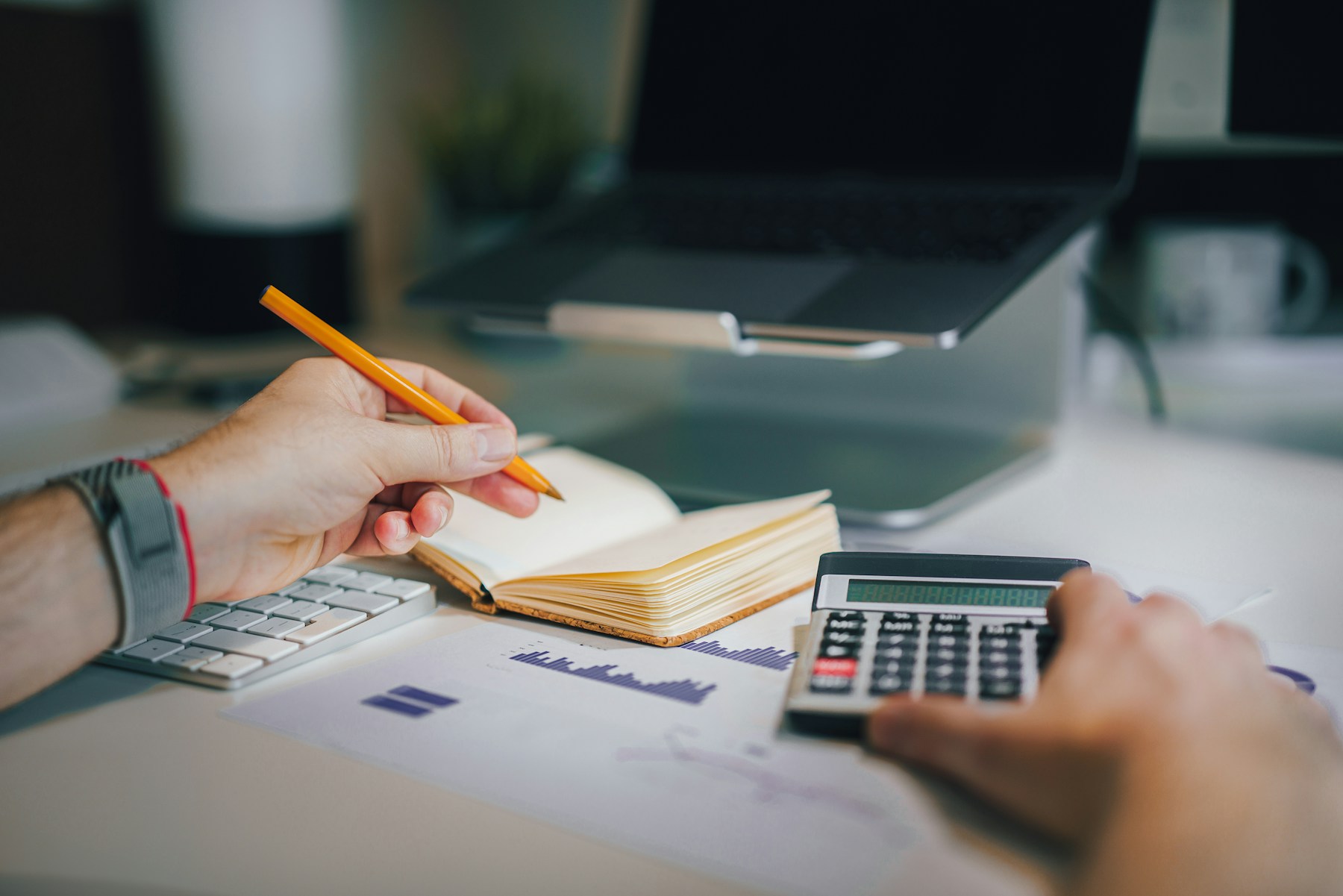 Person reviewing retirement paperwork with a calculator and notebook