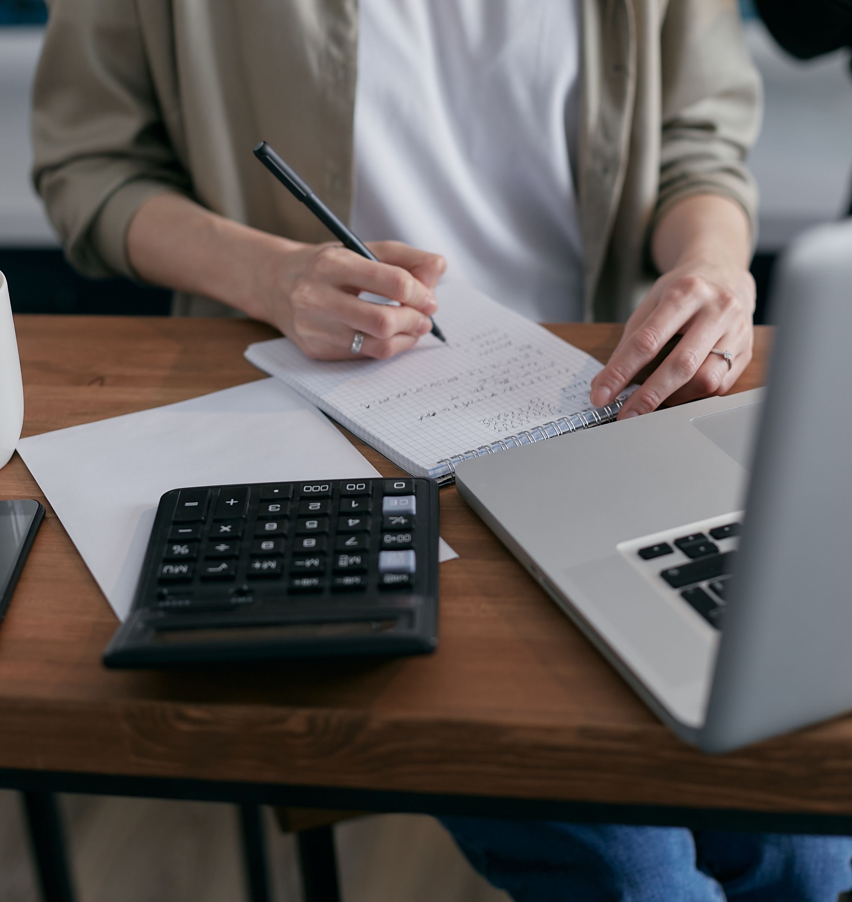 Person organizing notes and a calculator for a financial review