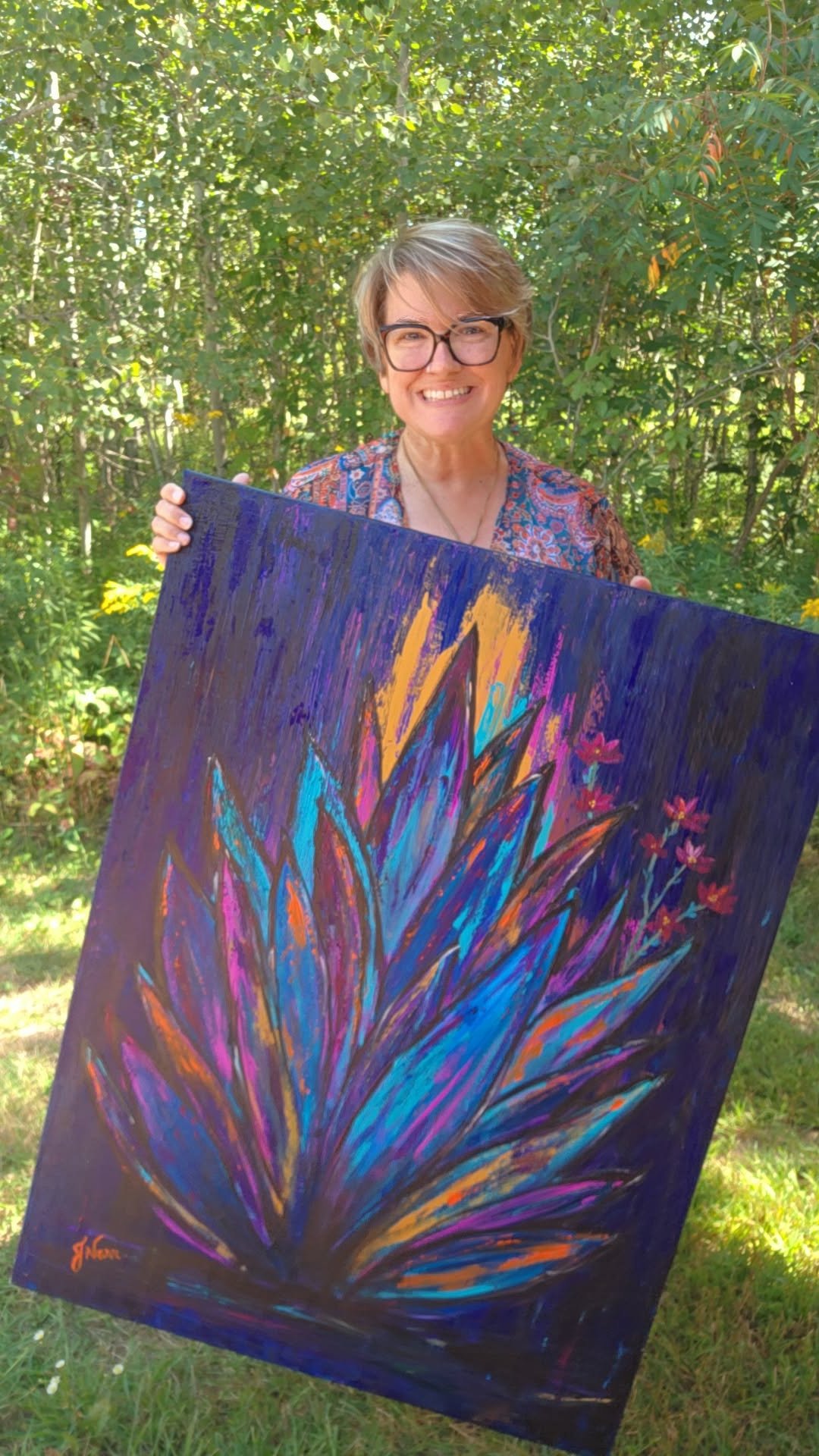 Jennifer Narr outdoors holding her original Wild & Untamed painting