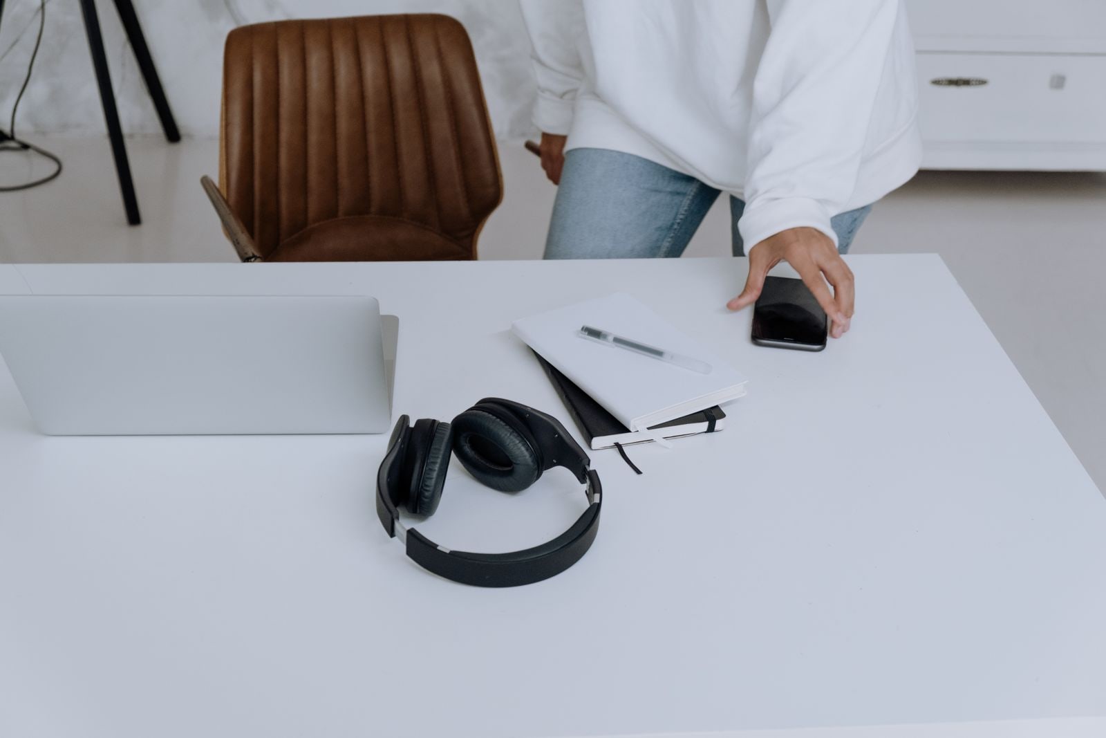 Headphones, a notebook, and a phone on a quiet desk