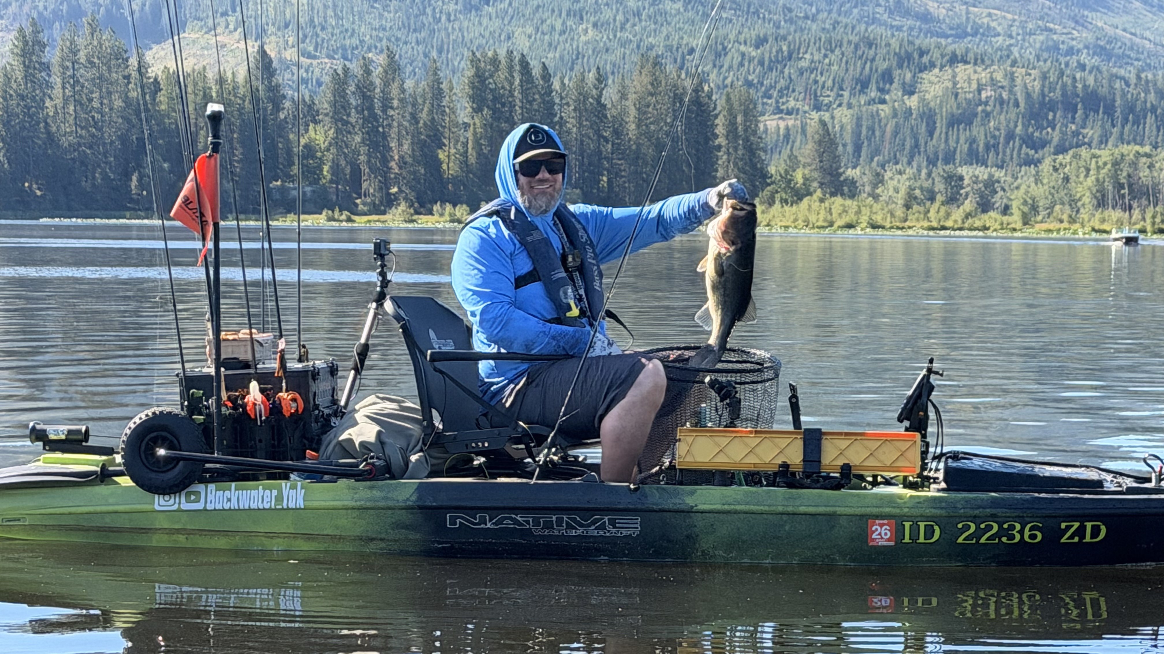 Kayak angler wearing a PFD on calm open water