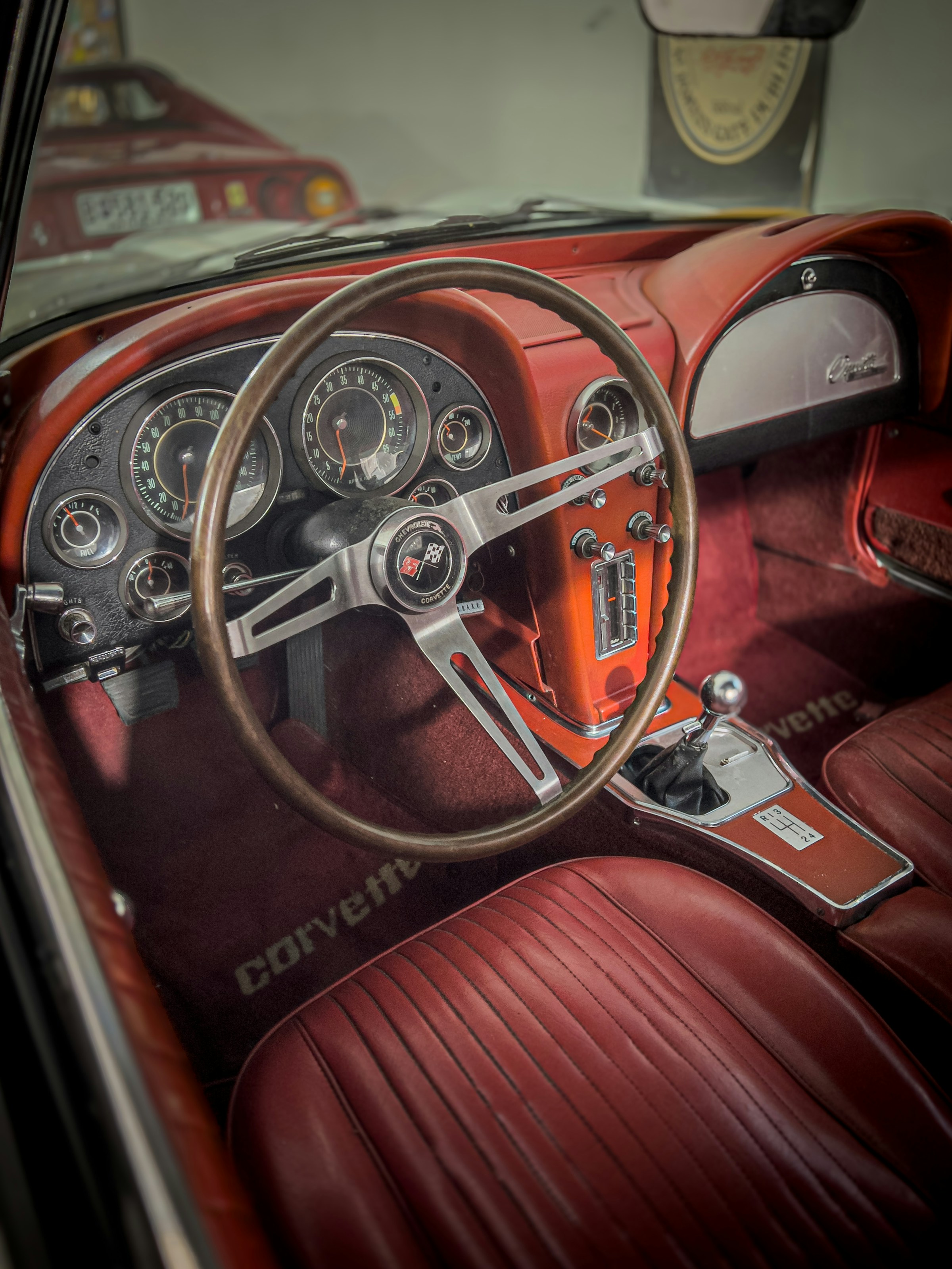 Classic car interior with wooden steering wheel and analog gauges