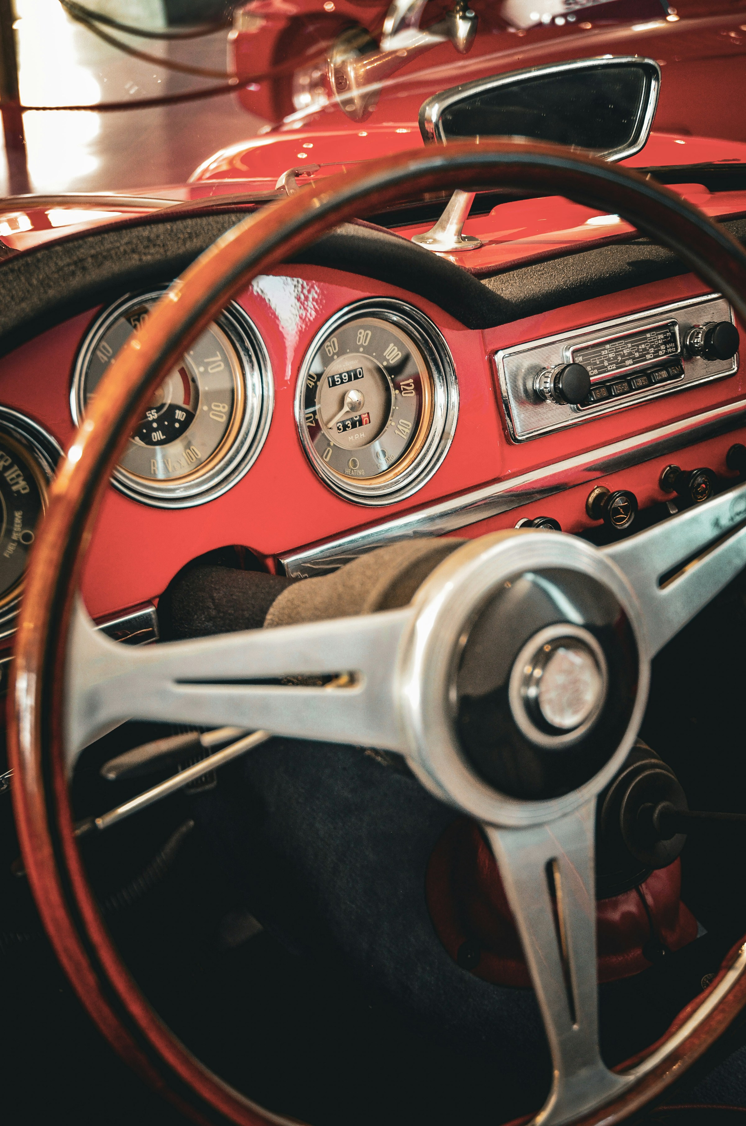 Red vintage car dashboard with wooden steering wheel