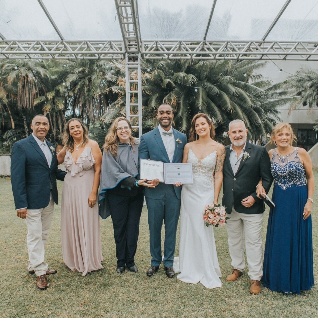 A complete wedding group posing together after an outdoor ceremony