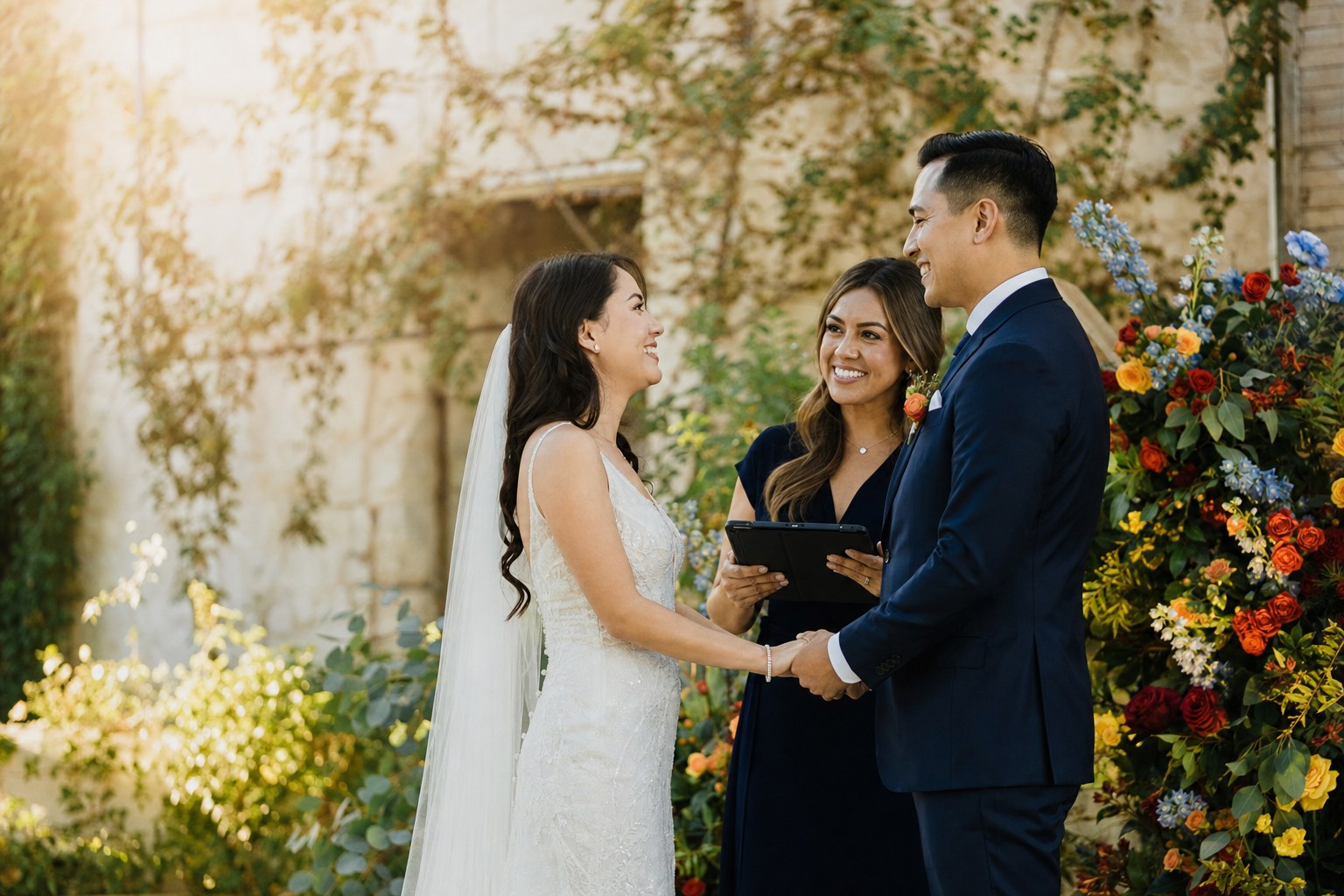 A couple exchanging vows with a celebrant at an outdoor ceremony