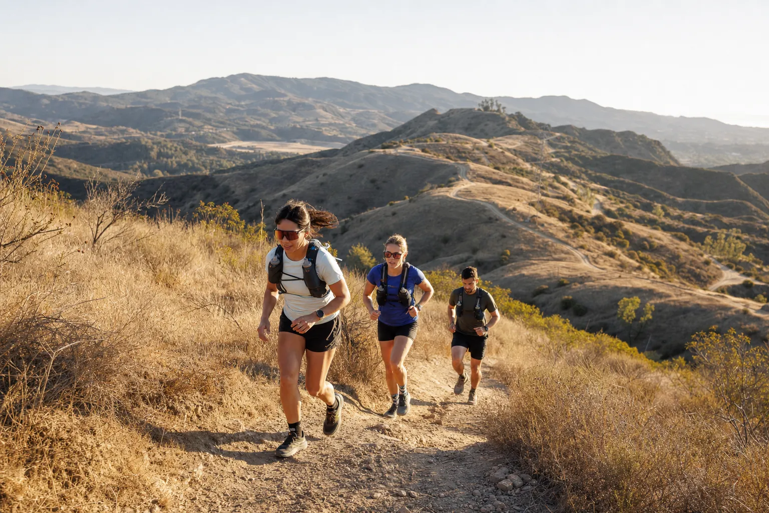 Trail runners moving along a dry Southern California hillside
