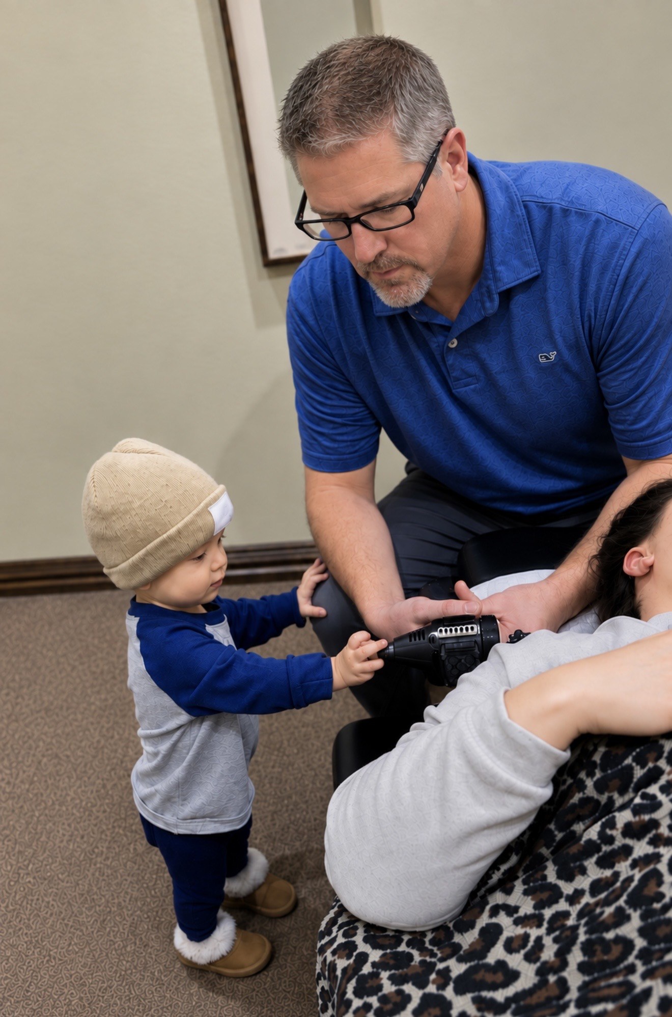 Dr. Bryan Stanton providing care while a young child watches
