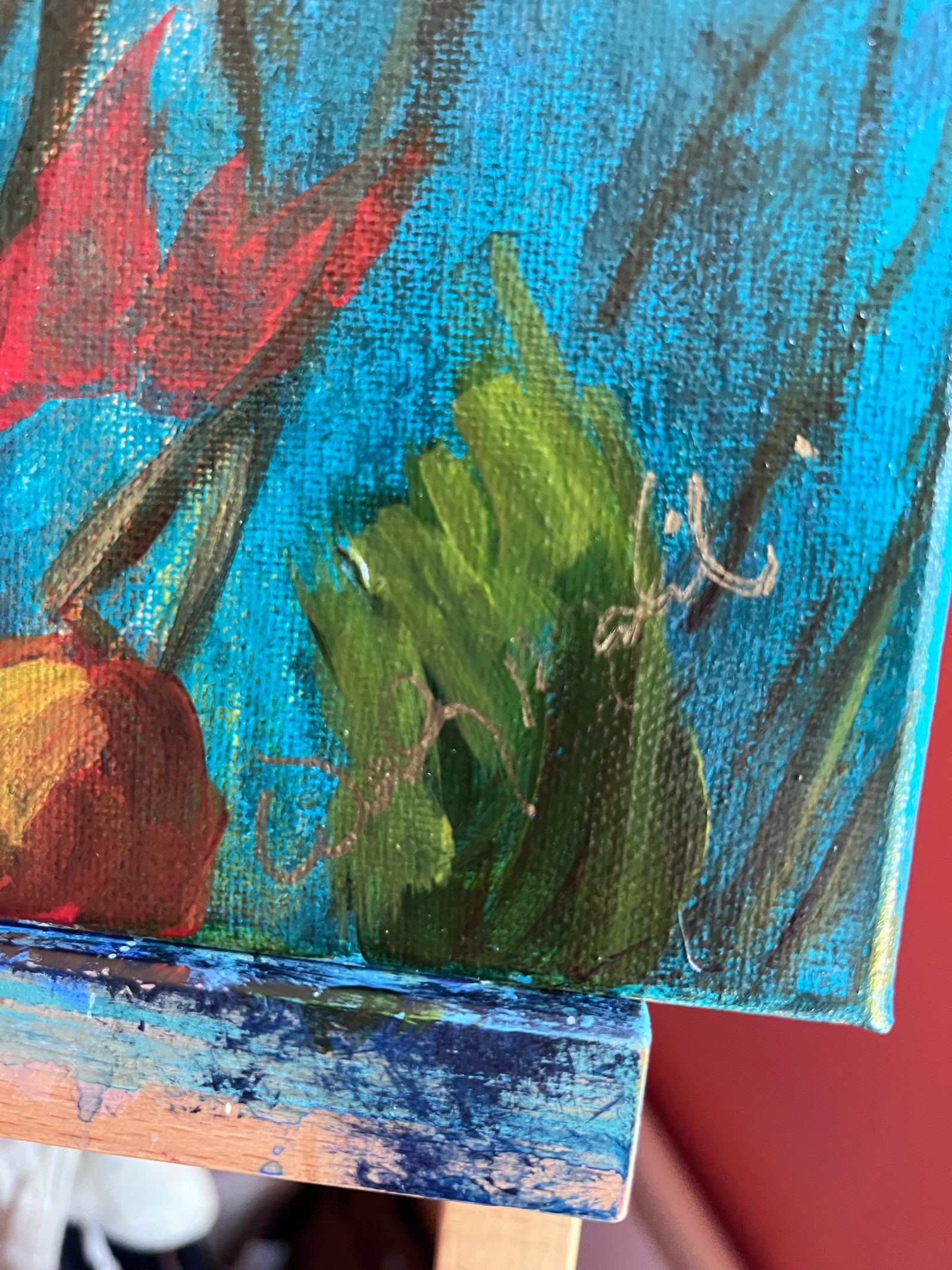 Close-up of green leaves and turquoise paint layers at the signed lower corner of the canvas