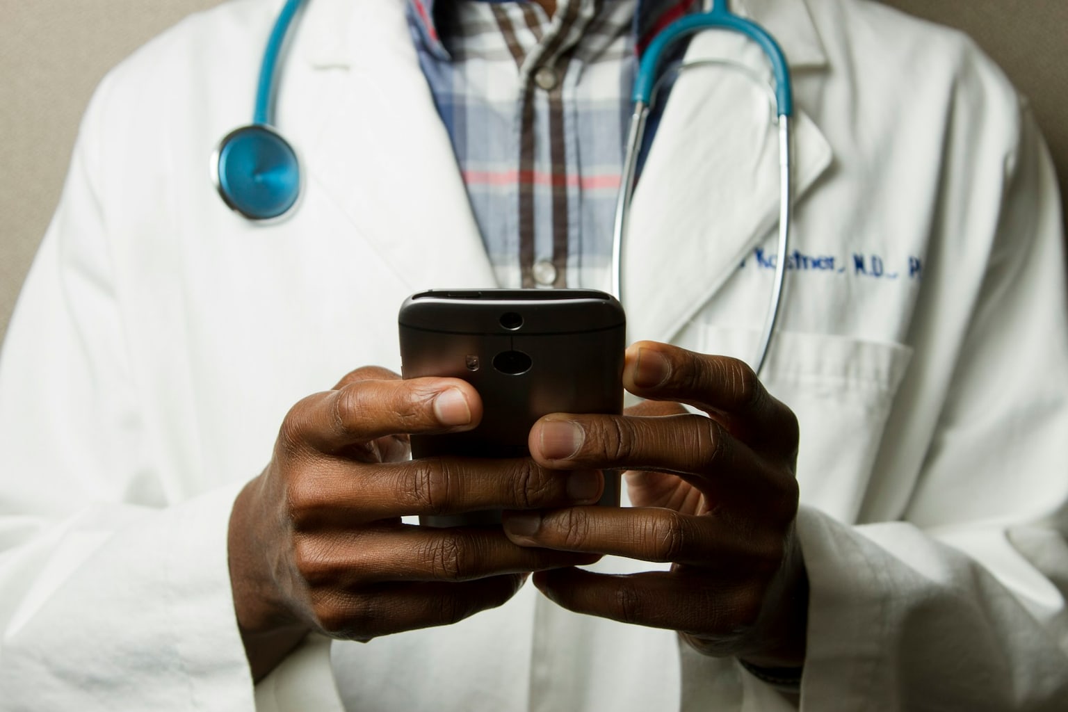 Healthcare professional using a phone, representing thoughtful candidate outreach