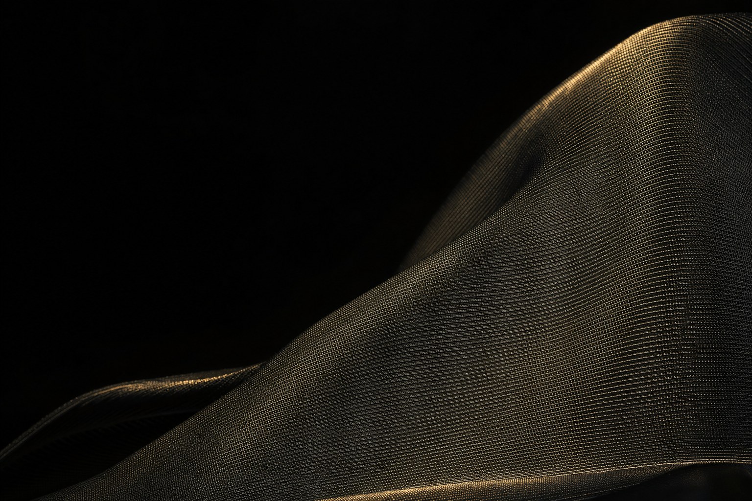 Dark metallic mesh lit along its folded surface.