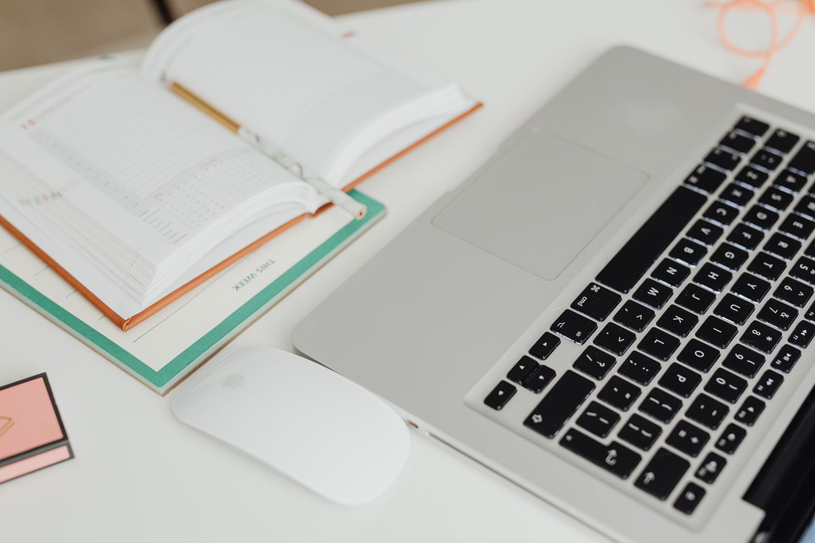 Laptop and planner arranged on a clean desk while an event invitation is prepared