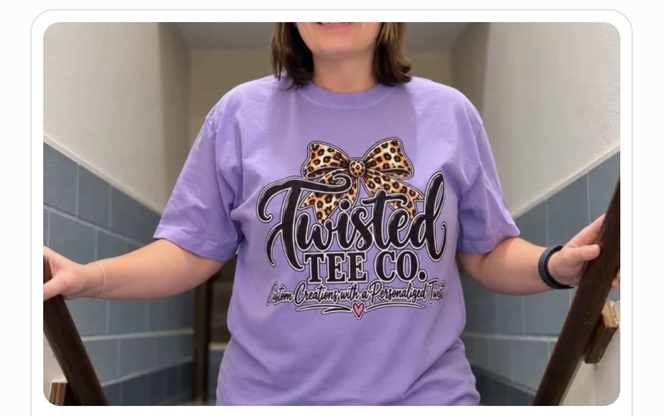 Britt’s purple Twisted Tee Co. logo tee with a leopard-print bow, shown as a business apparel example