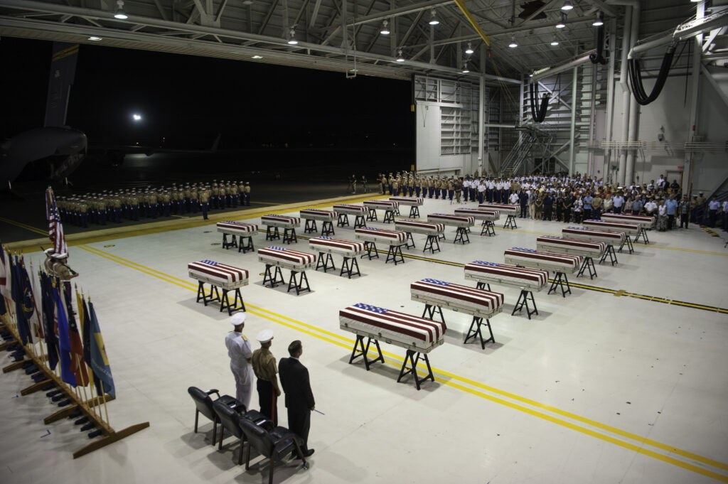 Service members carrying a flag-draped transfer case during an honorable carry