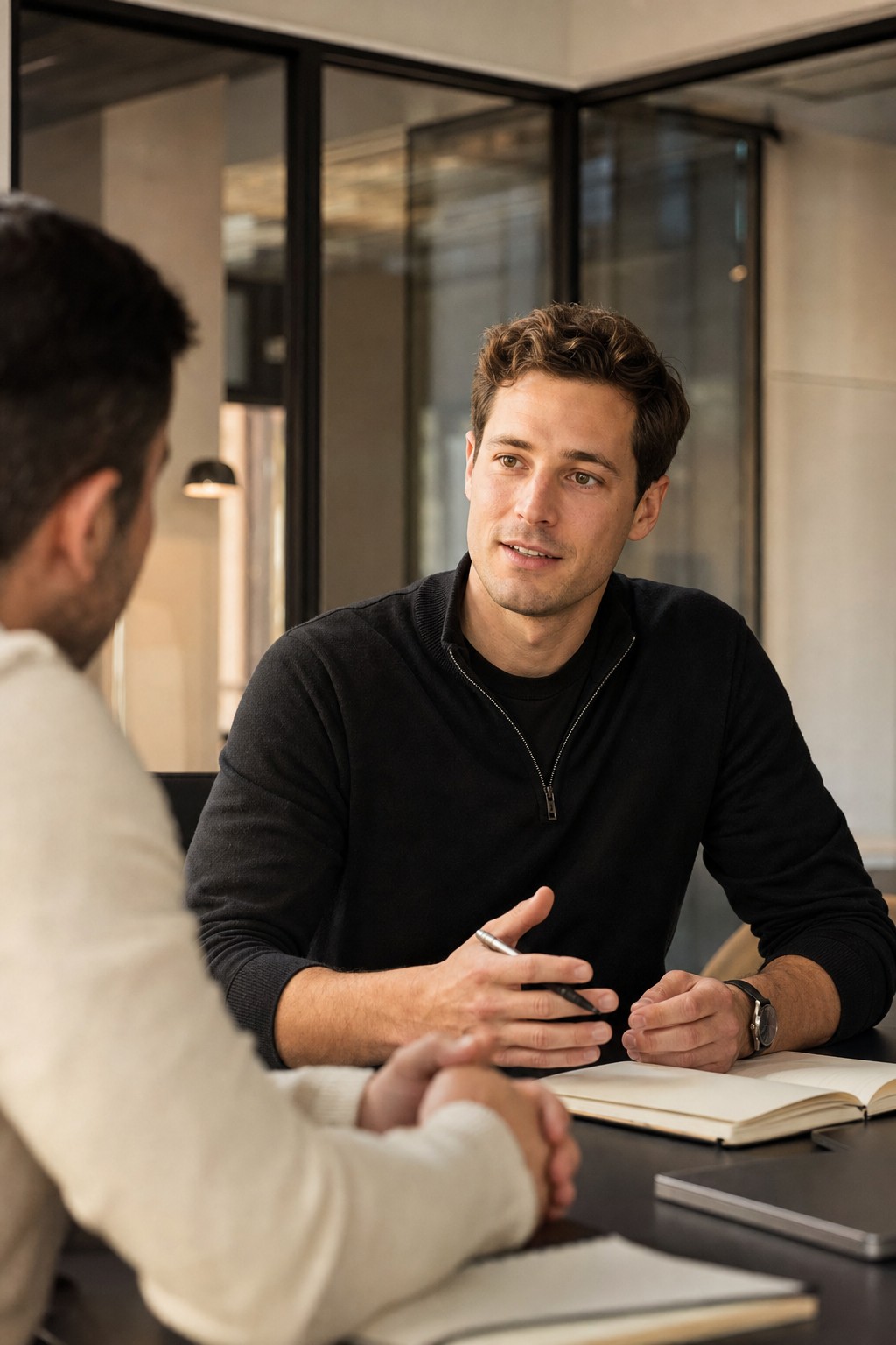 Two professionals in a focused conversation in a modern office