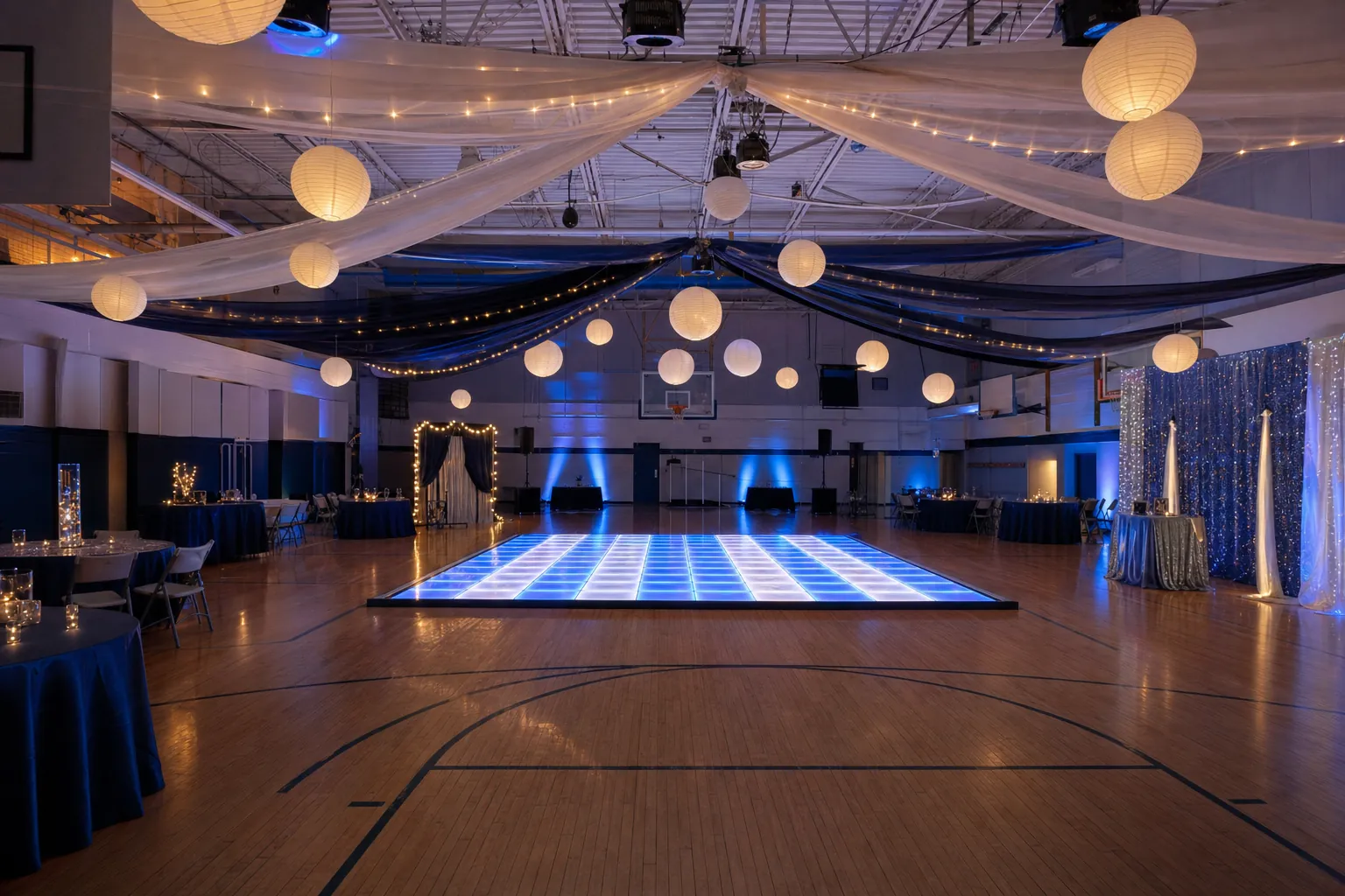 Guests enjoying a polished indoor celebration with a bright LED dance floor