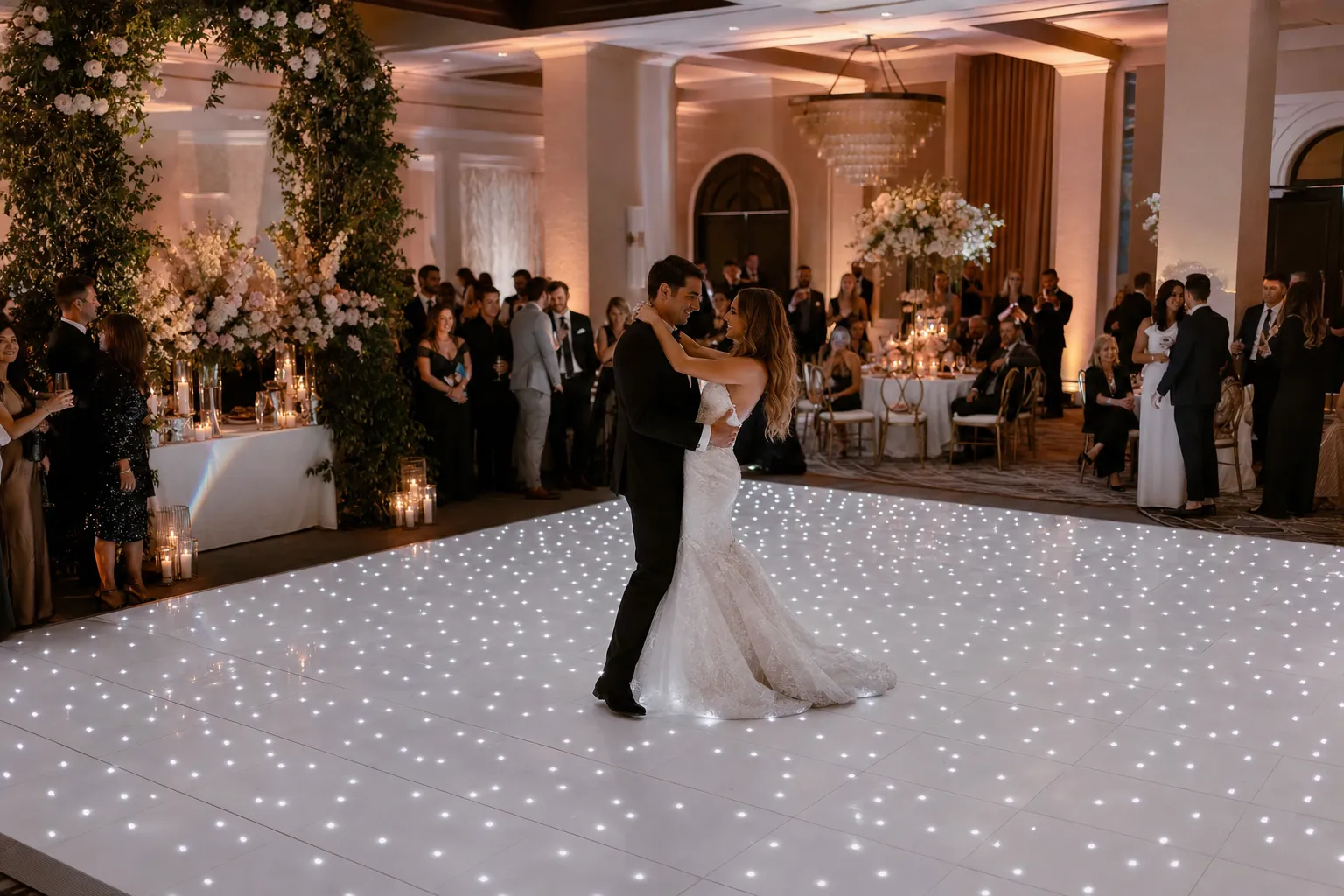Newlyweds dancing on a white LED dance floor at an elegant wedding reception