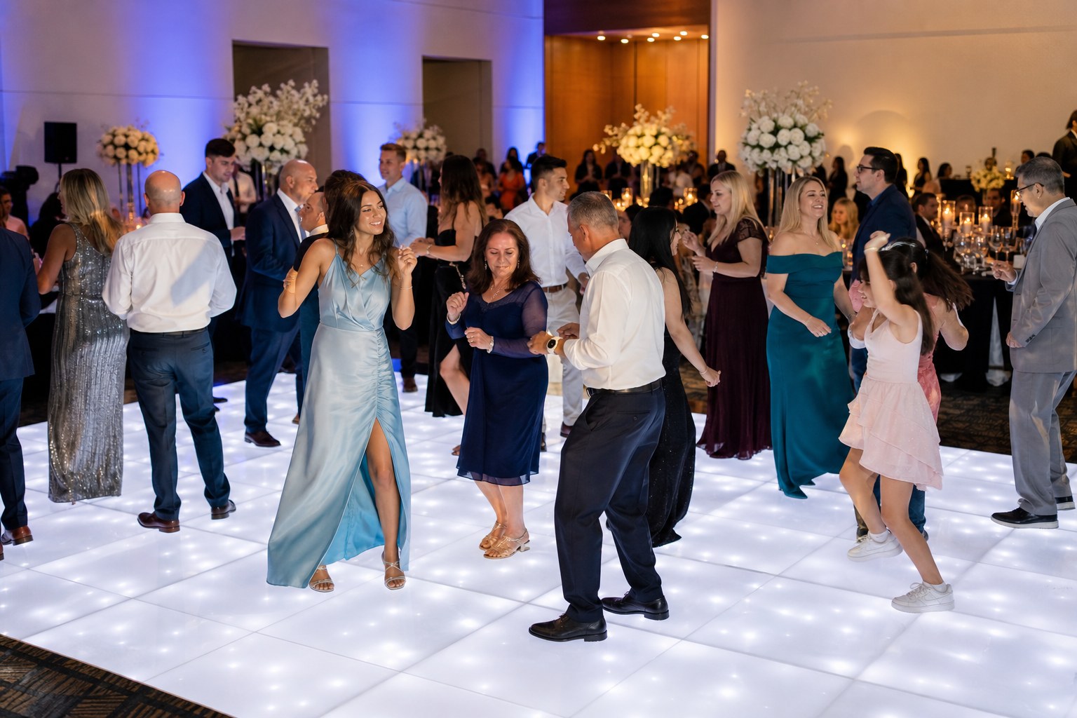 Guests celebrating together on a bright illuminated LED dance floor