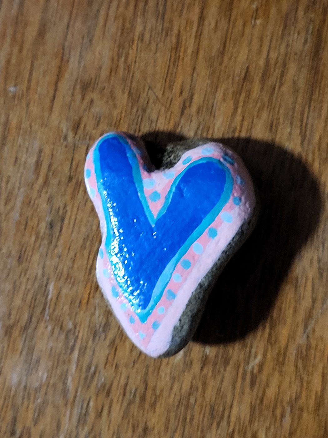 Naturally heart-shaped stone with a blue heart and pink painted border