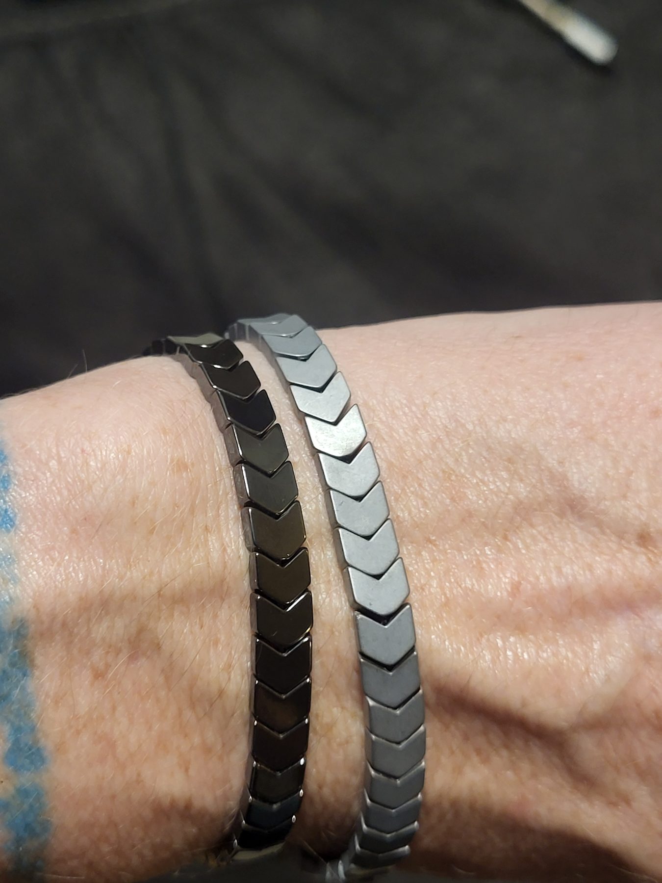 Two contrasting hematite bracelets worn together on a wrist