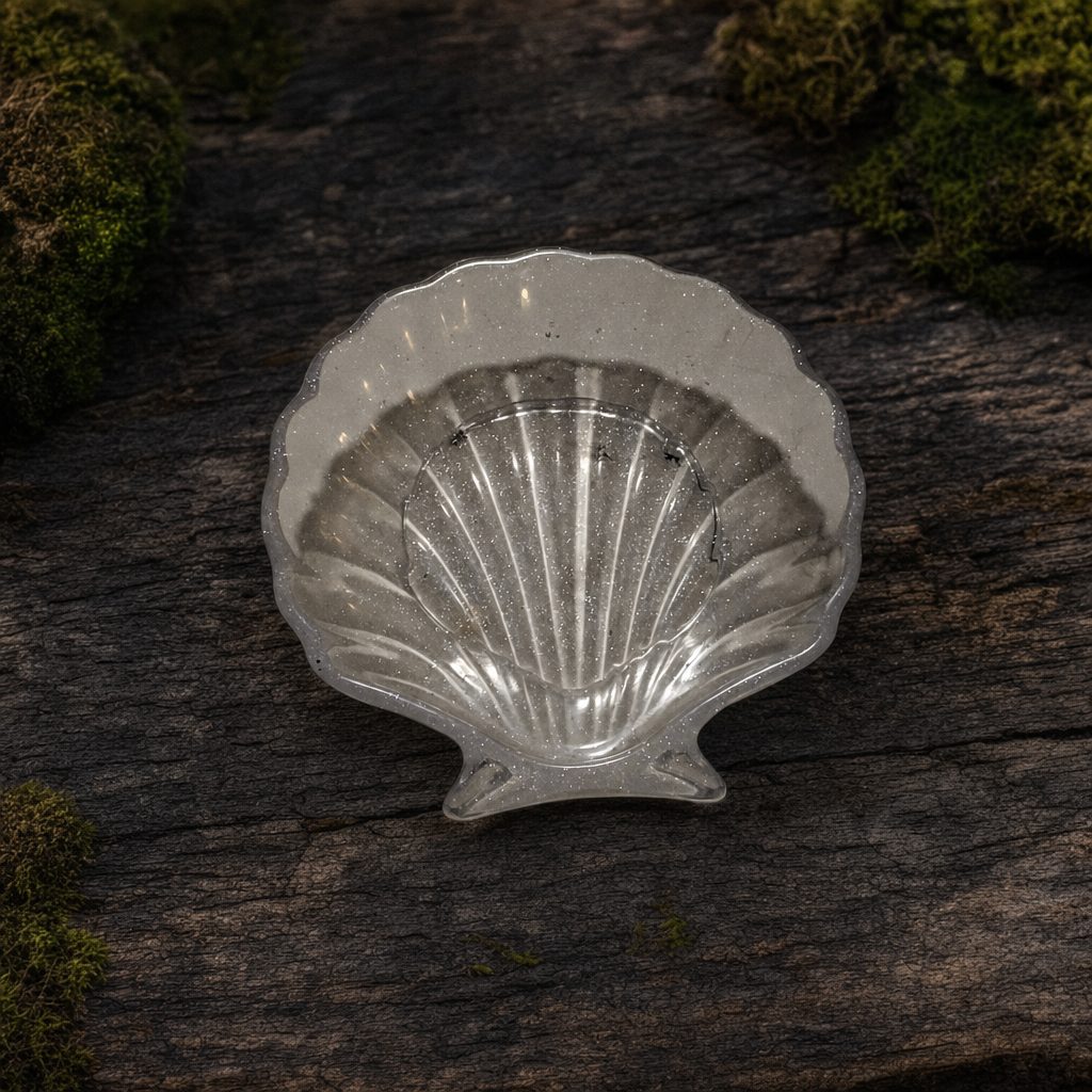 Shimmery pearl shell-shaped resin trinket dish on dark woodland wood