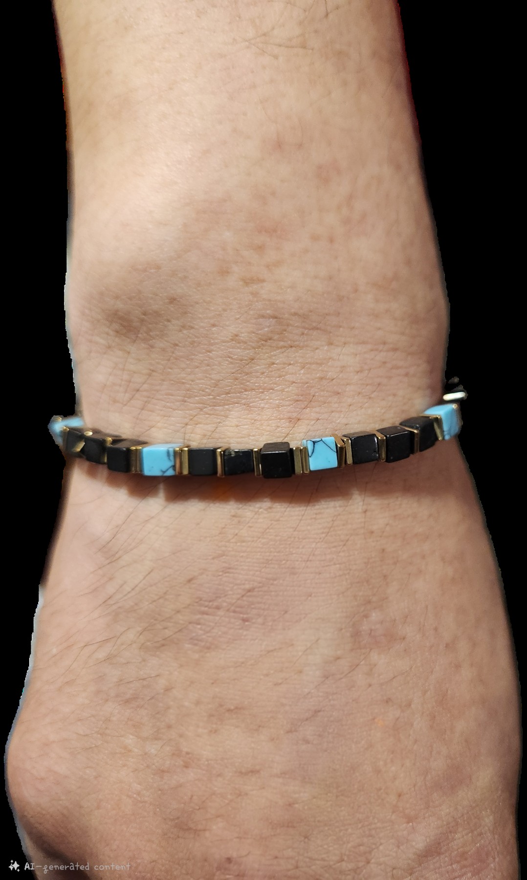 Bracelet with rectangular black and teal accents and gold-colored edges, worn on a wrist