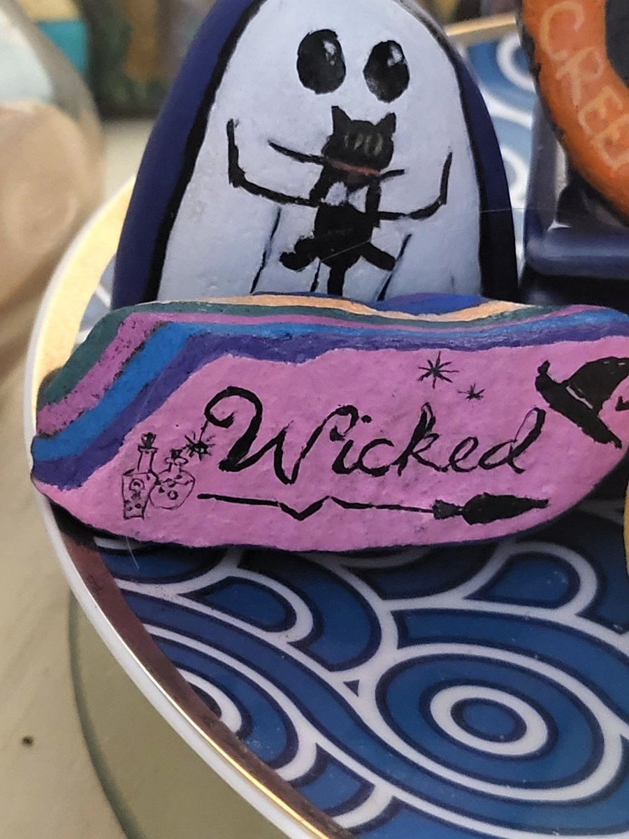 Hand-painted white ghost holding a black cat, paired with a pink rock reading Wicked