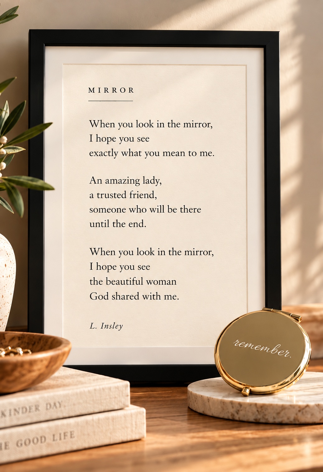 Mirror framed poem styled on a sunlit tabletop beside a small gold mirror