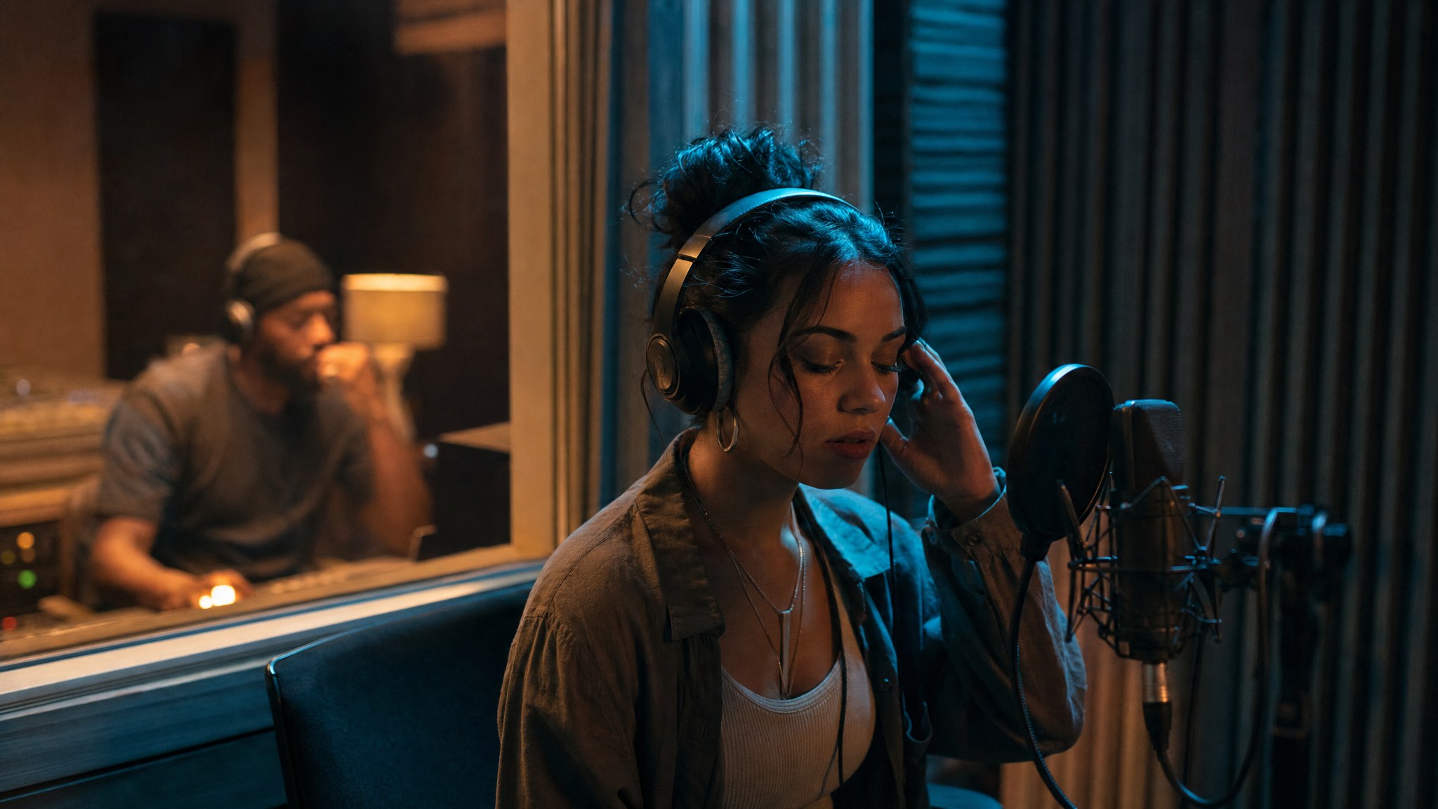 Independent vocalist listening back to a recording in a studio booth
