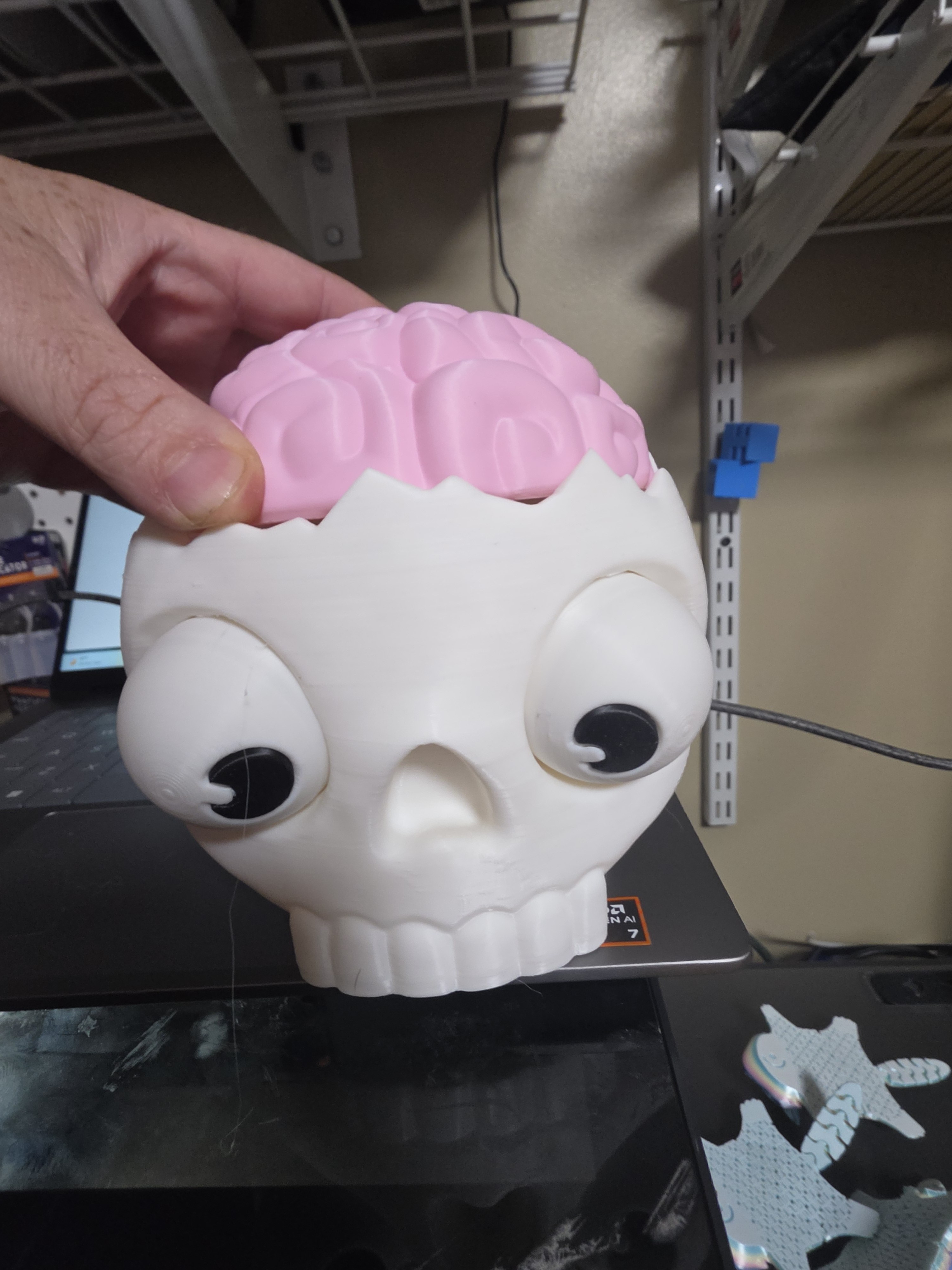 Pink-brain skull figure on the printer