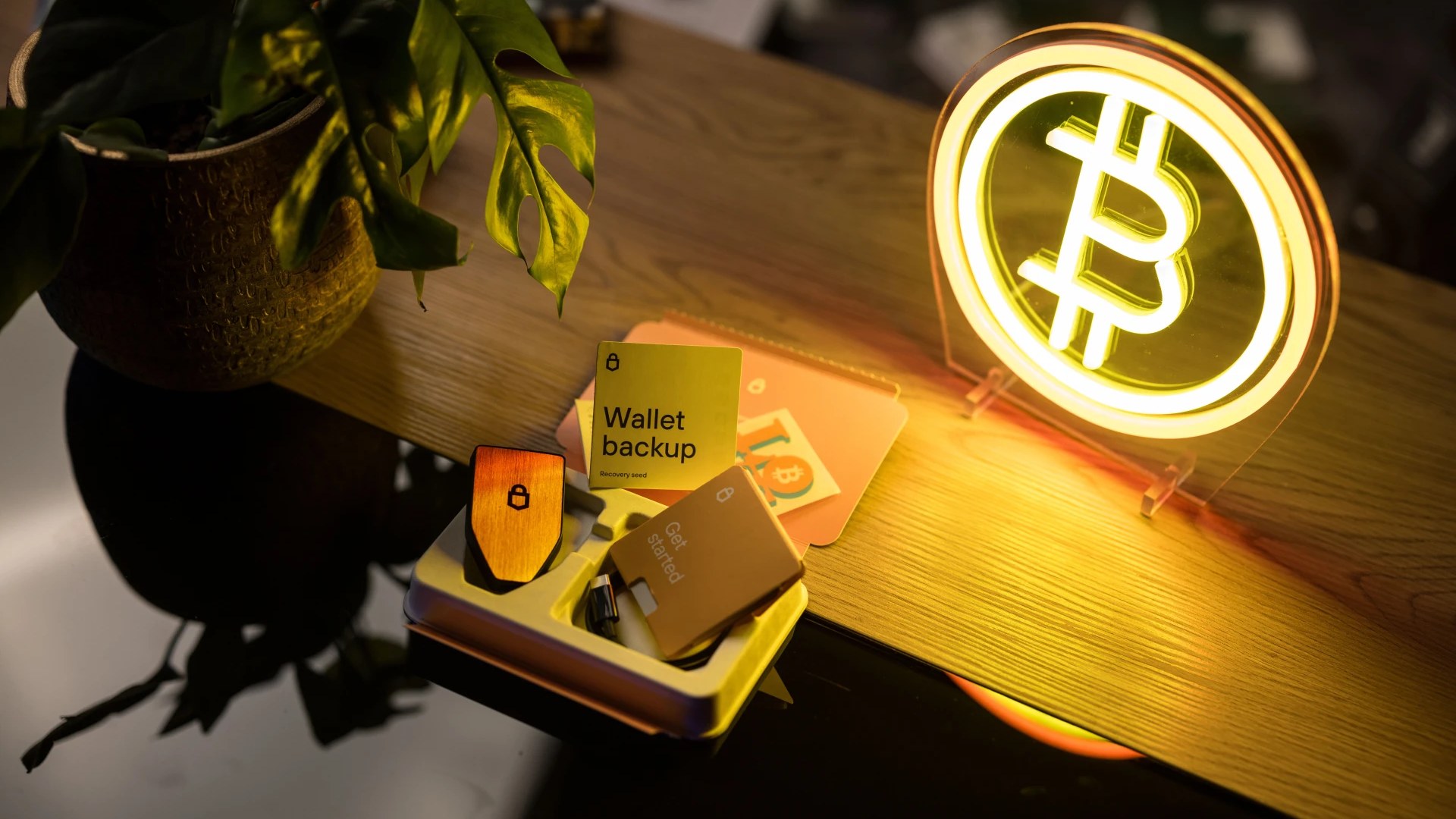 A Trezor Safe 5 beside its package and wallet backup materials on a desk