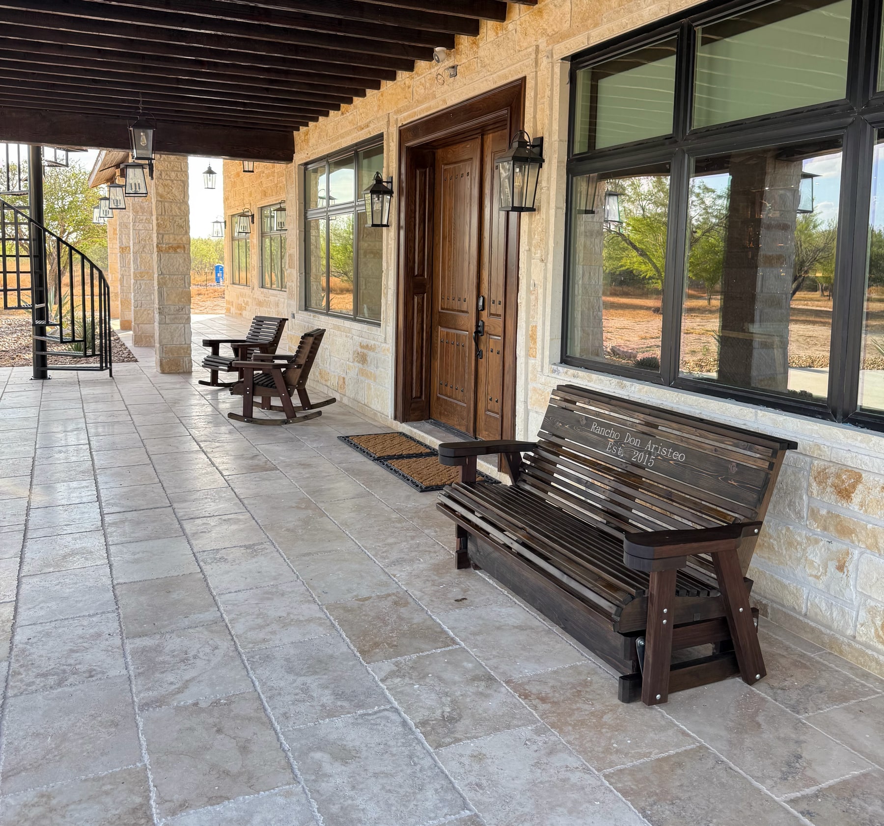 Handcrafted cedar seating on a covered stone porch