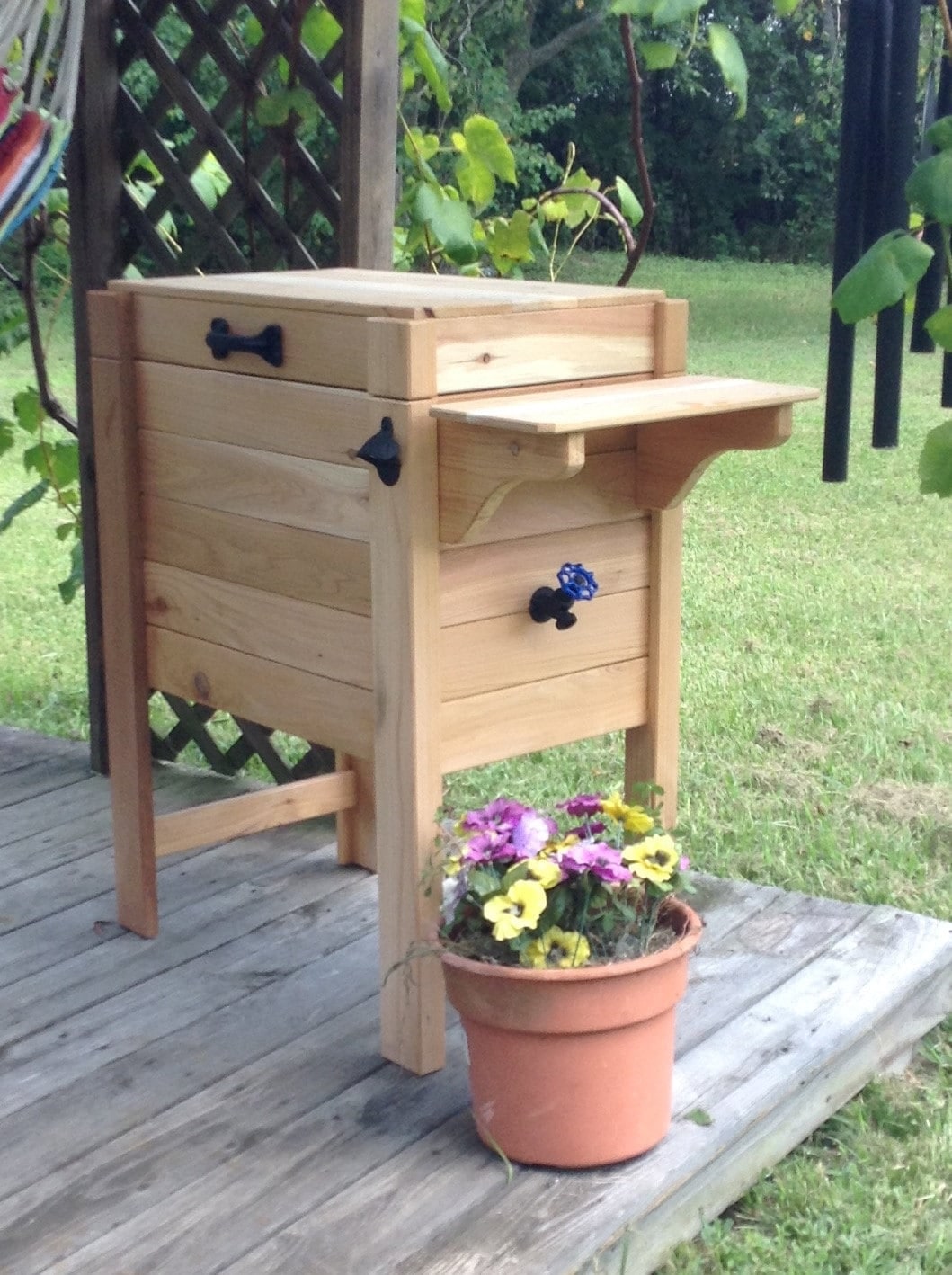 Handcrafted cedar cooler stand positioned for easy backyard serving