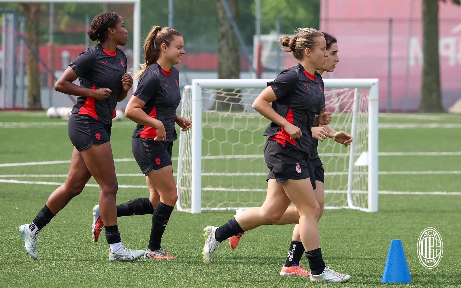 Professional women footballers training on a pitch