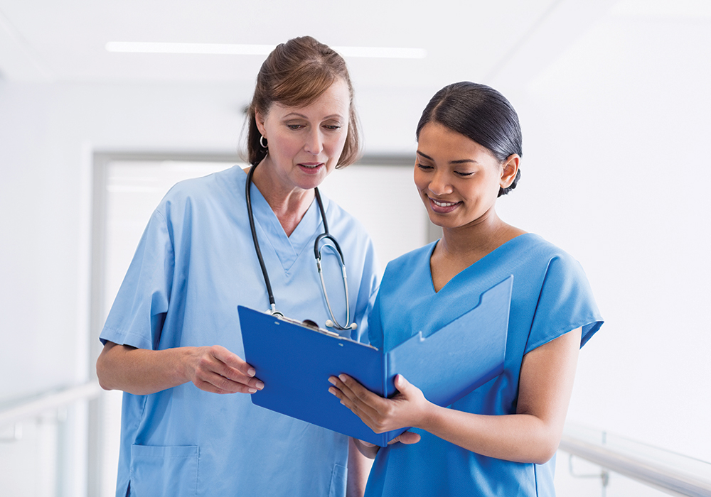 Nurse preceptor and new nurse reviewing observations together