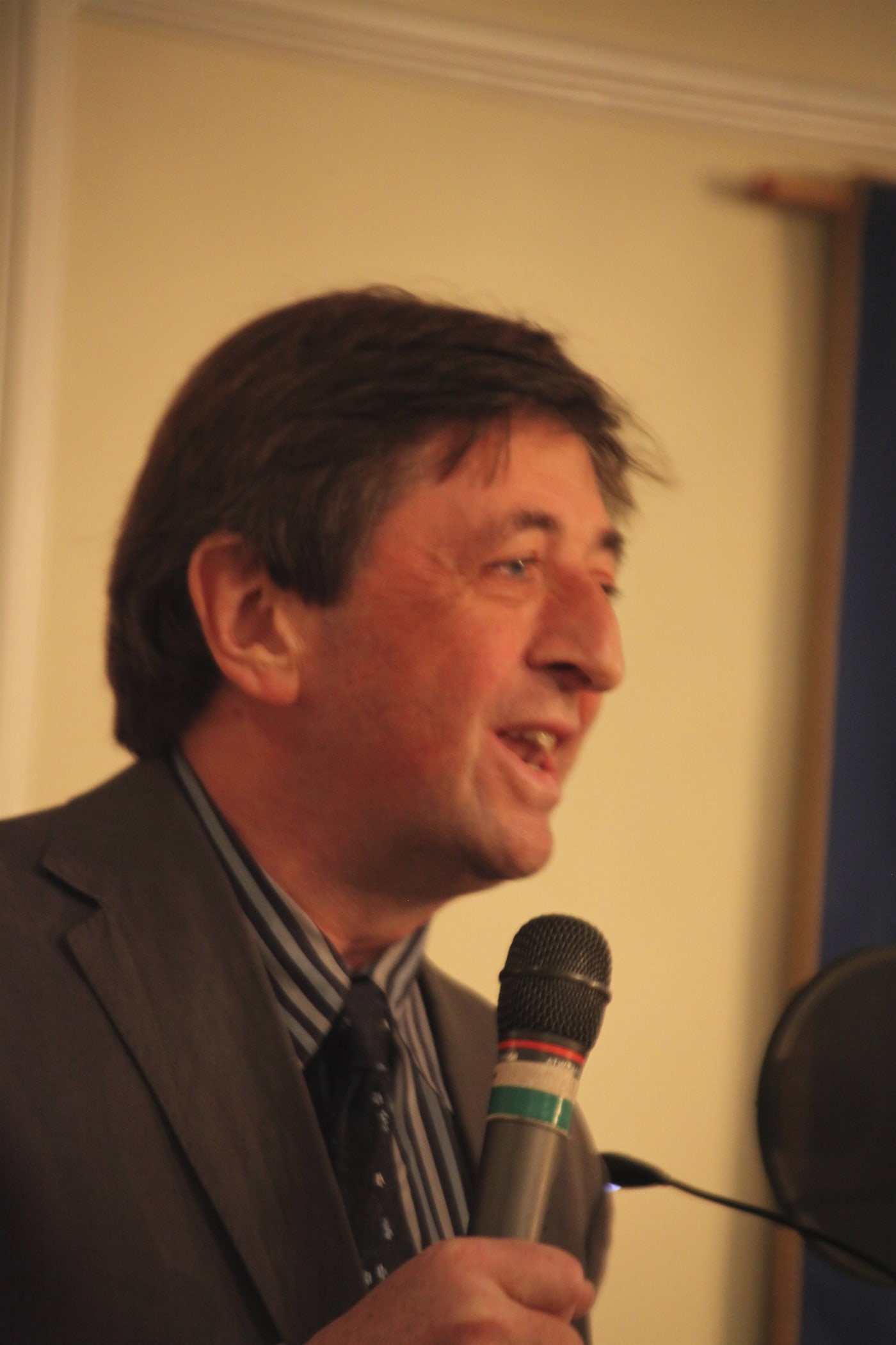 Mark McDonald speaking into a microphone