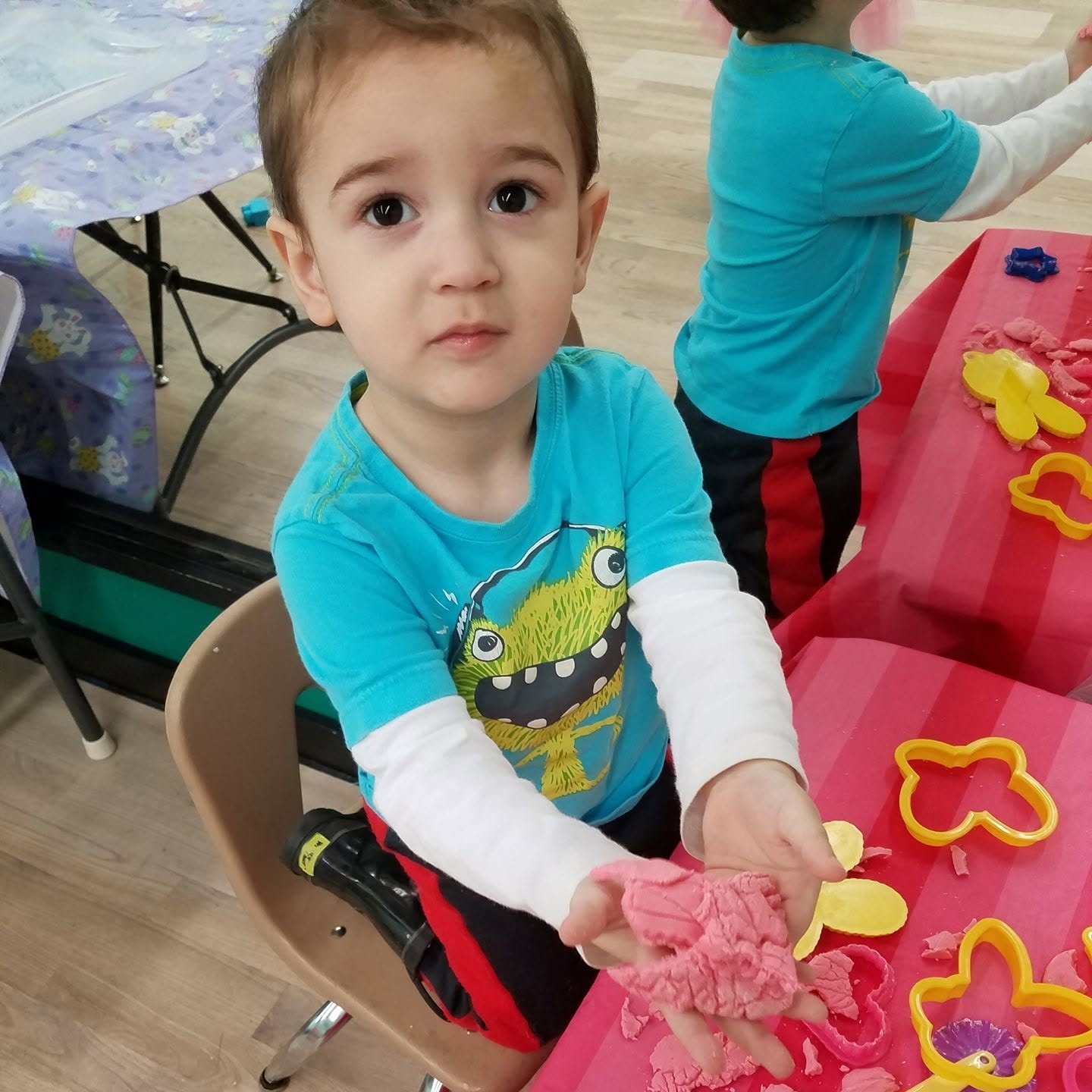 Preschool child showing a playdough creation