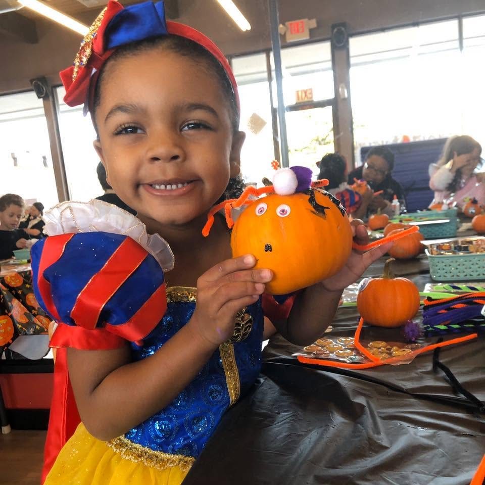 Preschool child proudly showing a decorated pumpkin