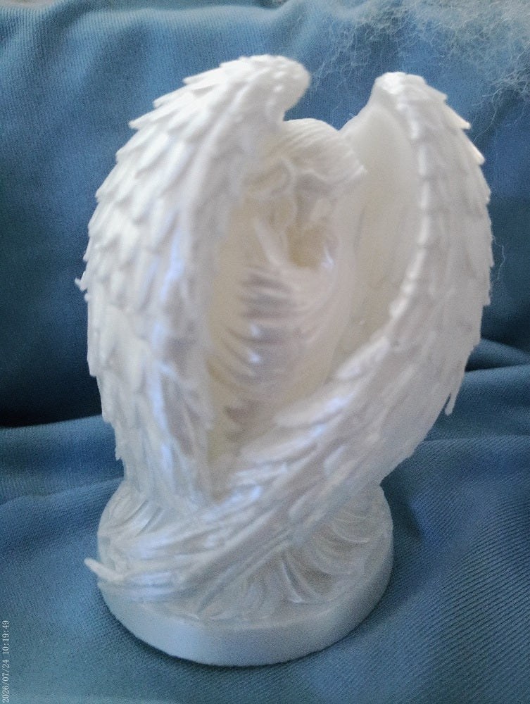 A white angel figurine with softly folded removable wings