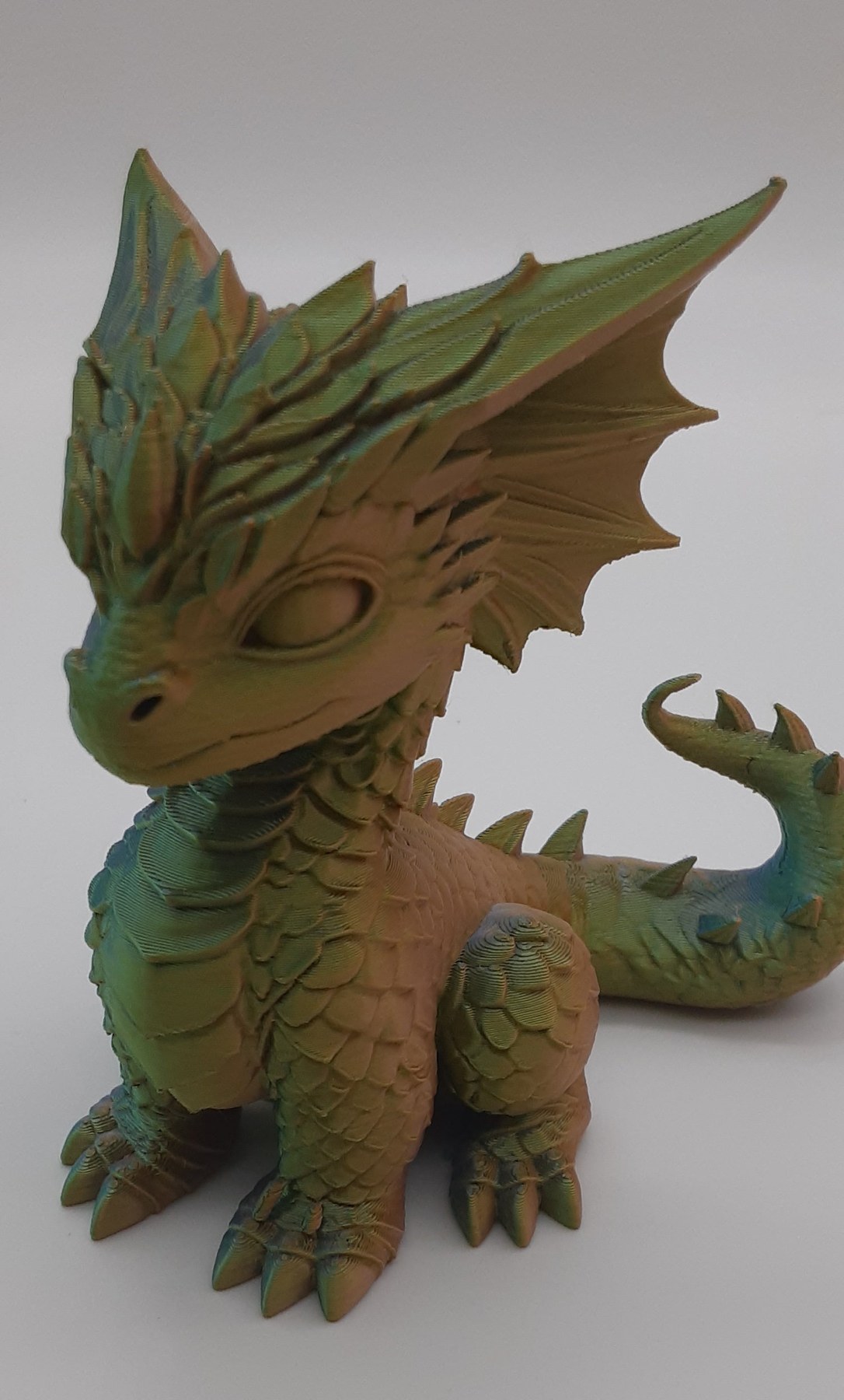 A colorful handmade 3D-printed baby dragon figurine, ready to give as a Christmas gift