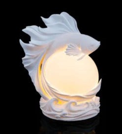 A handmade luminous betta fish orb that adds a warm glow to a shelf or desk