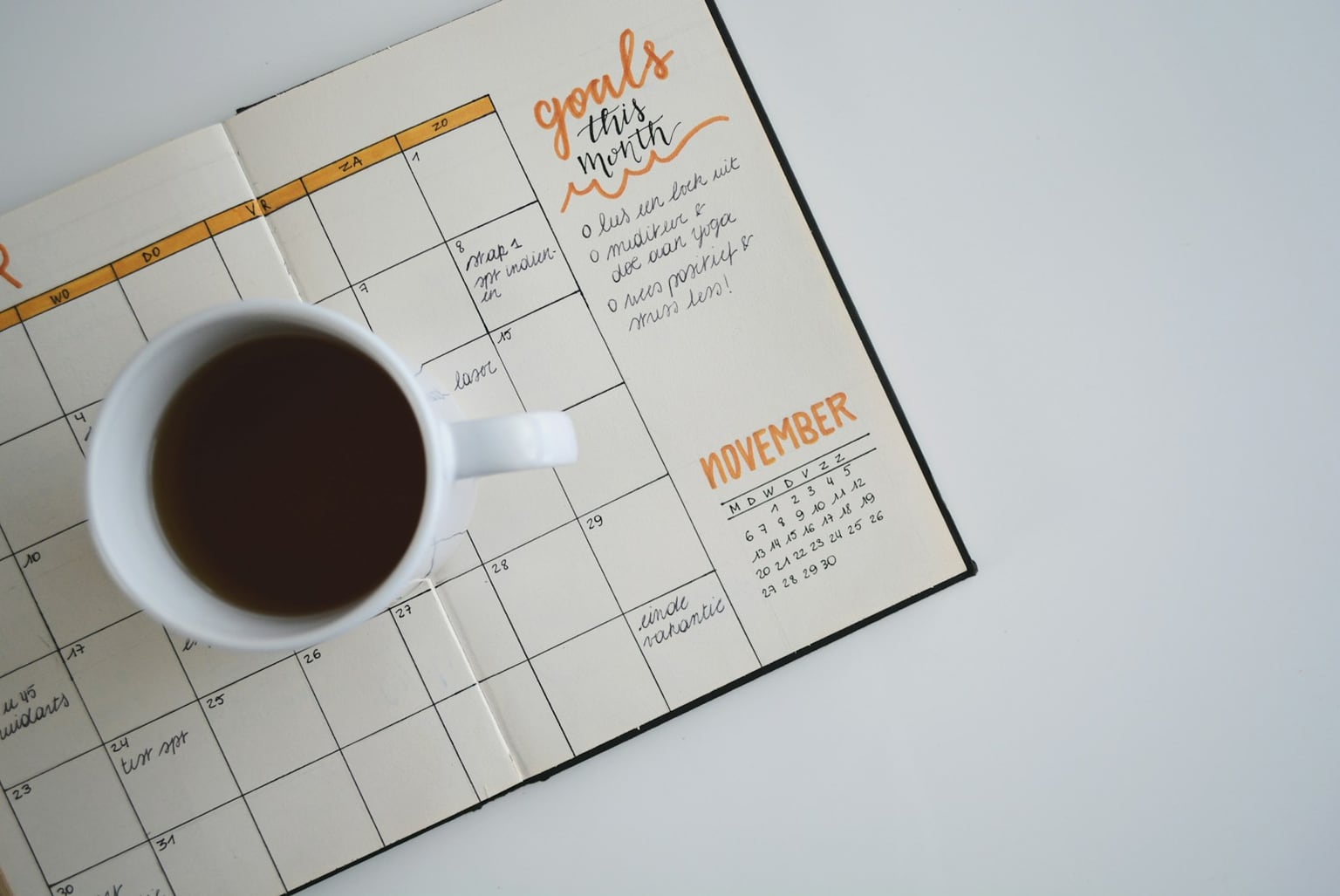 Open calendar and coffee cup on a clean desk