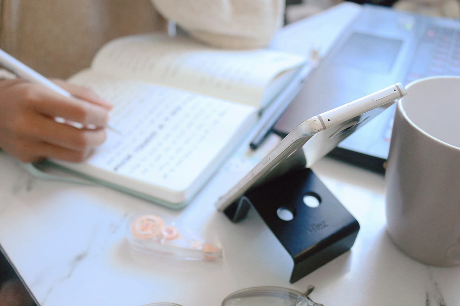 Person writing notes at a desk