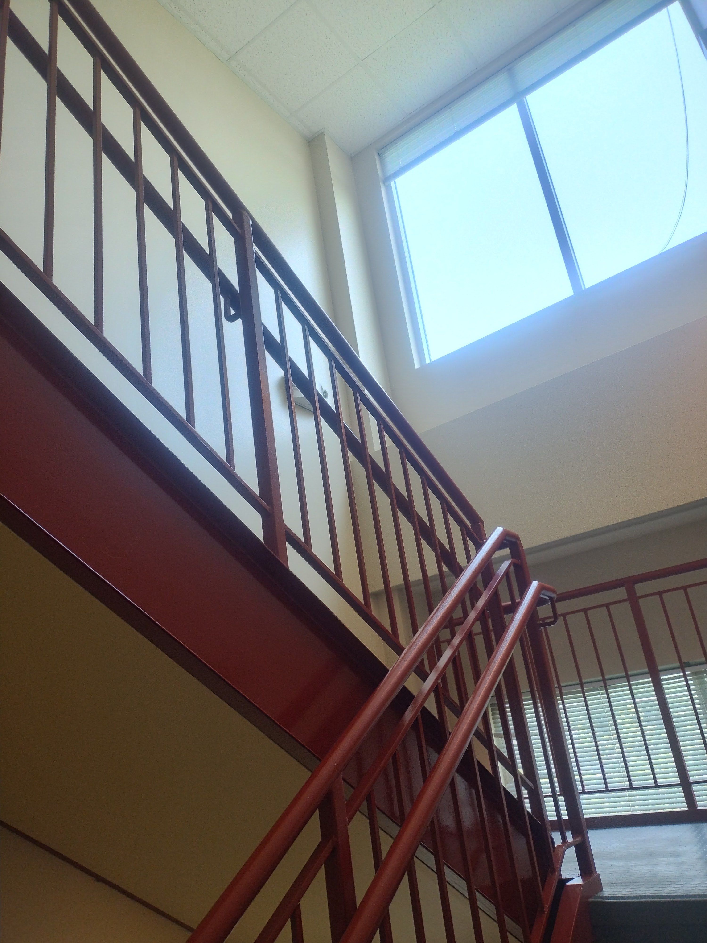 Finished stairway walls and railings near a landing