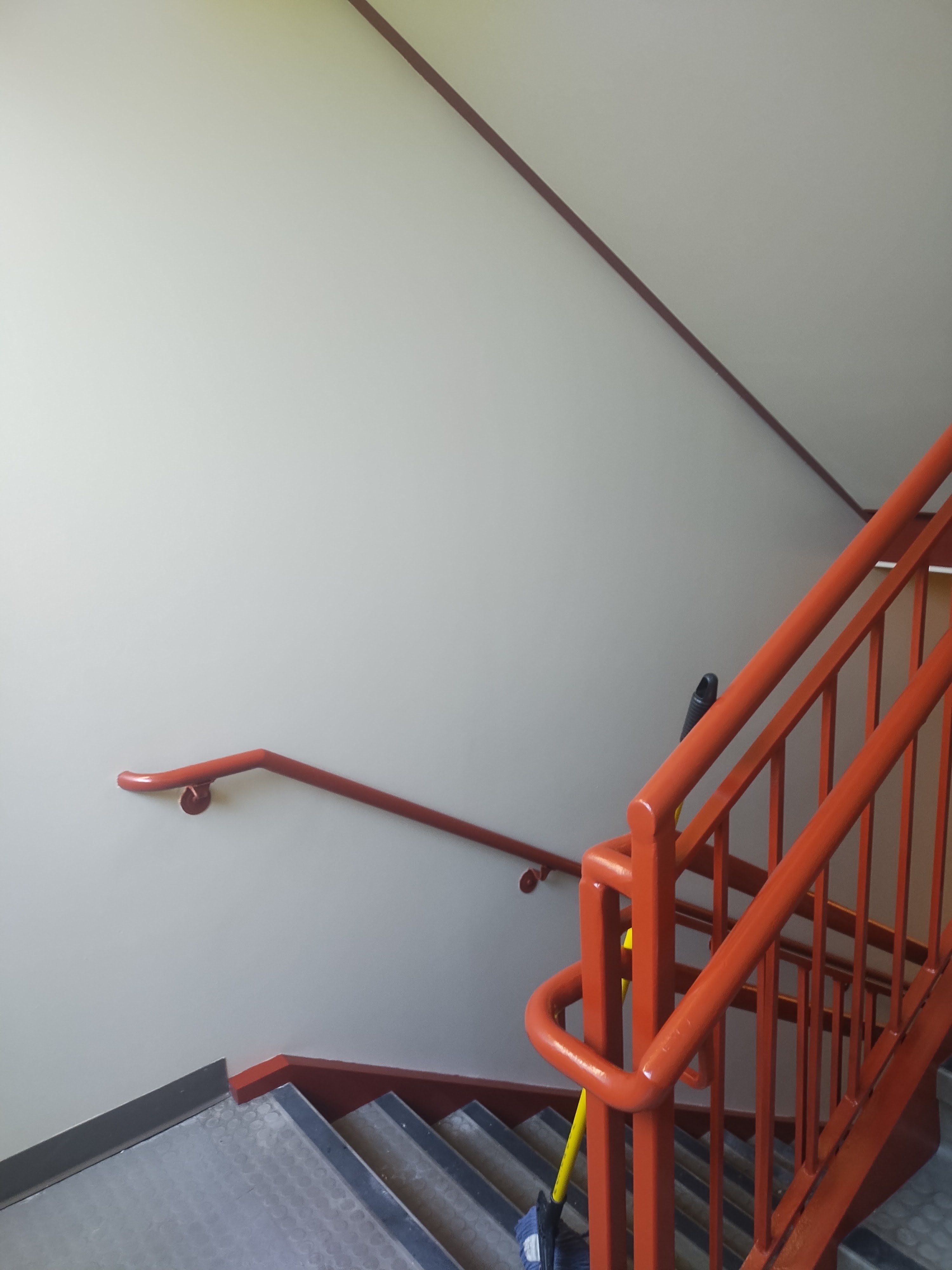 Commercial stair treads and red handrail after repainting