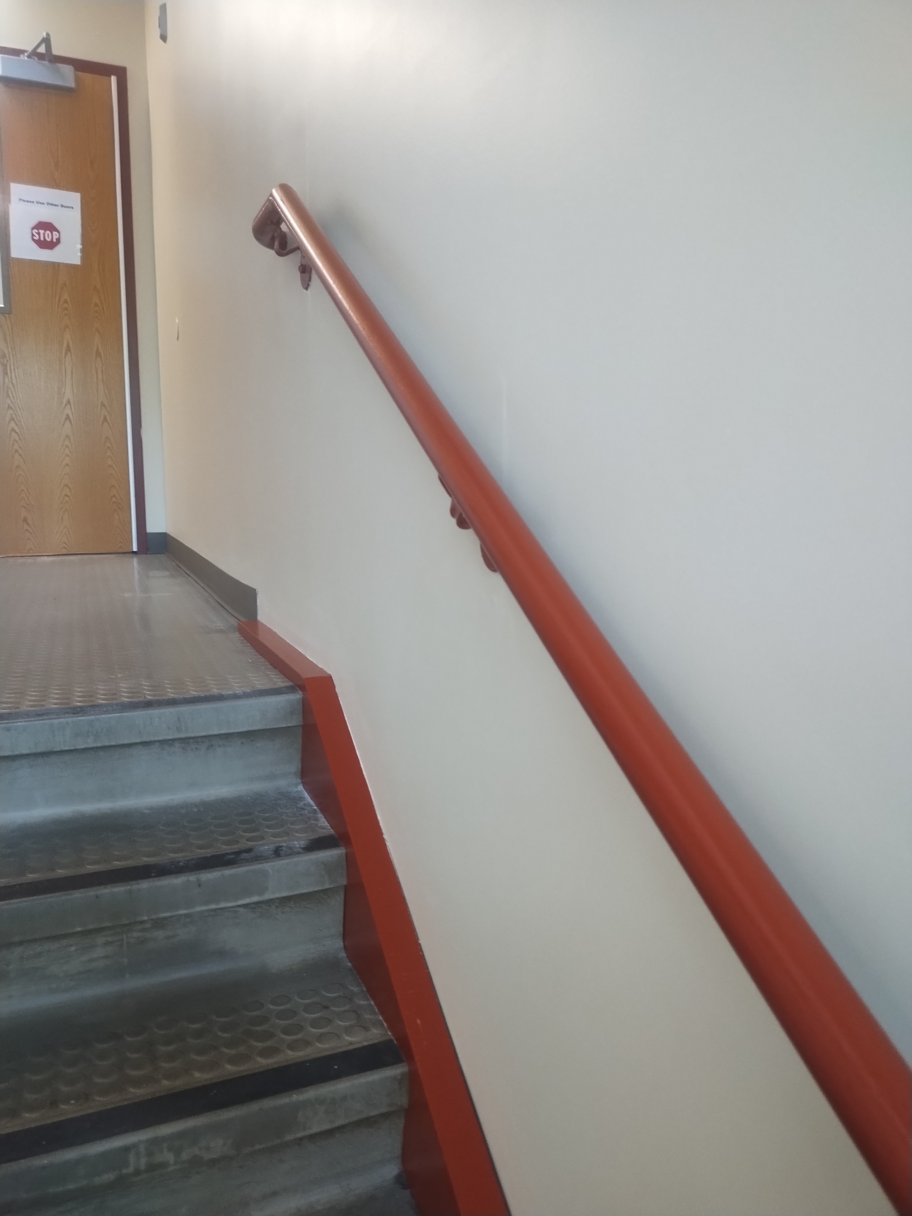Red railings continuing through a commercial stairwell