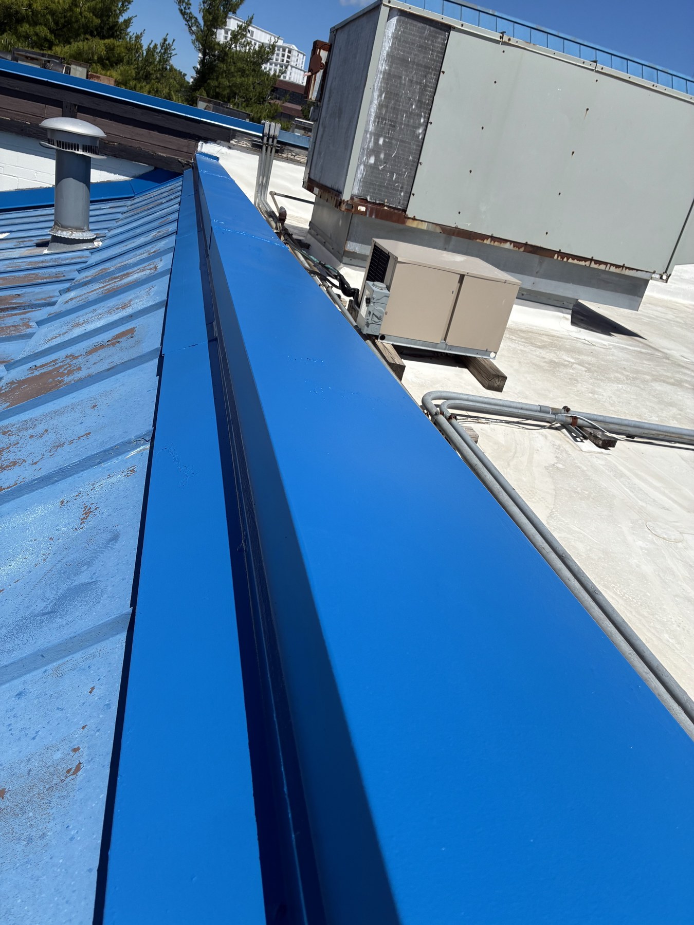 Roof ridge preparation beside commercial equipment